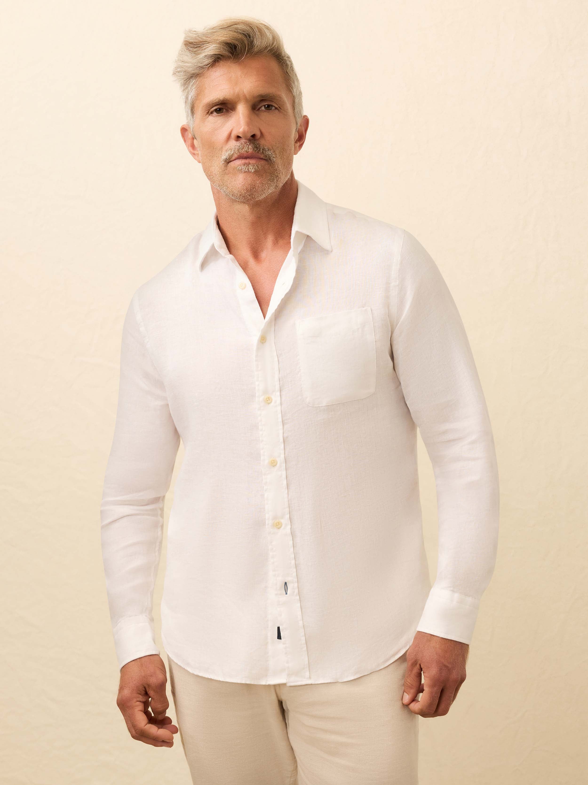 Man wearing a white linen shirt against a beige background