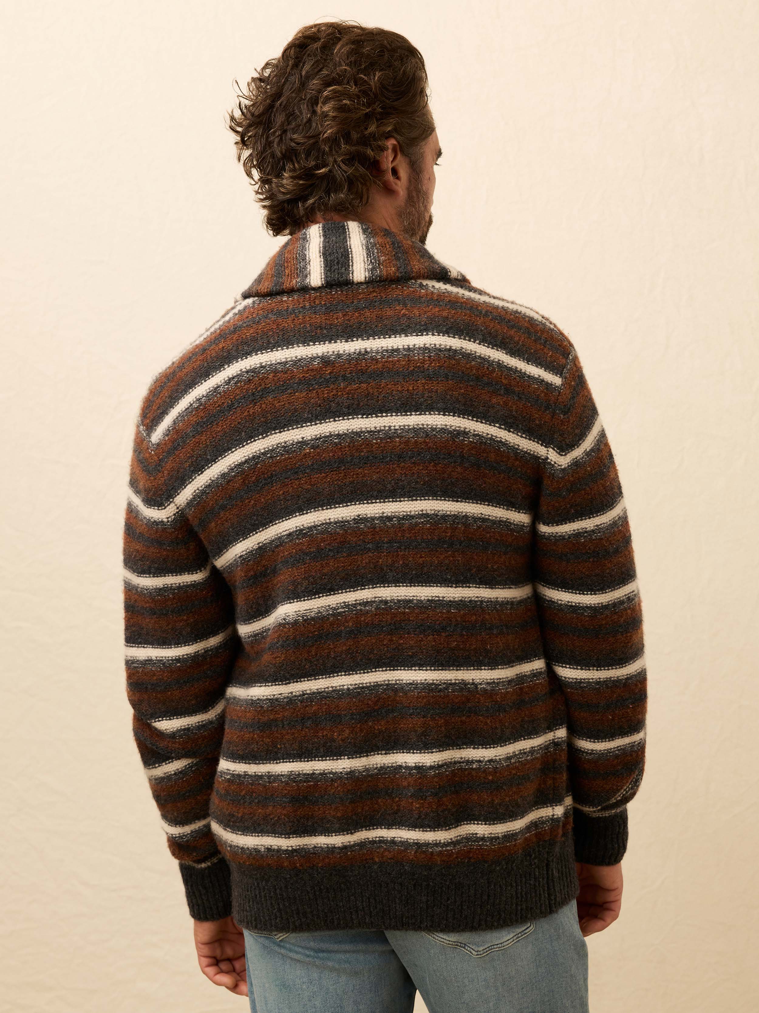 Man wearing a brown striped cardigan against a beige background