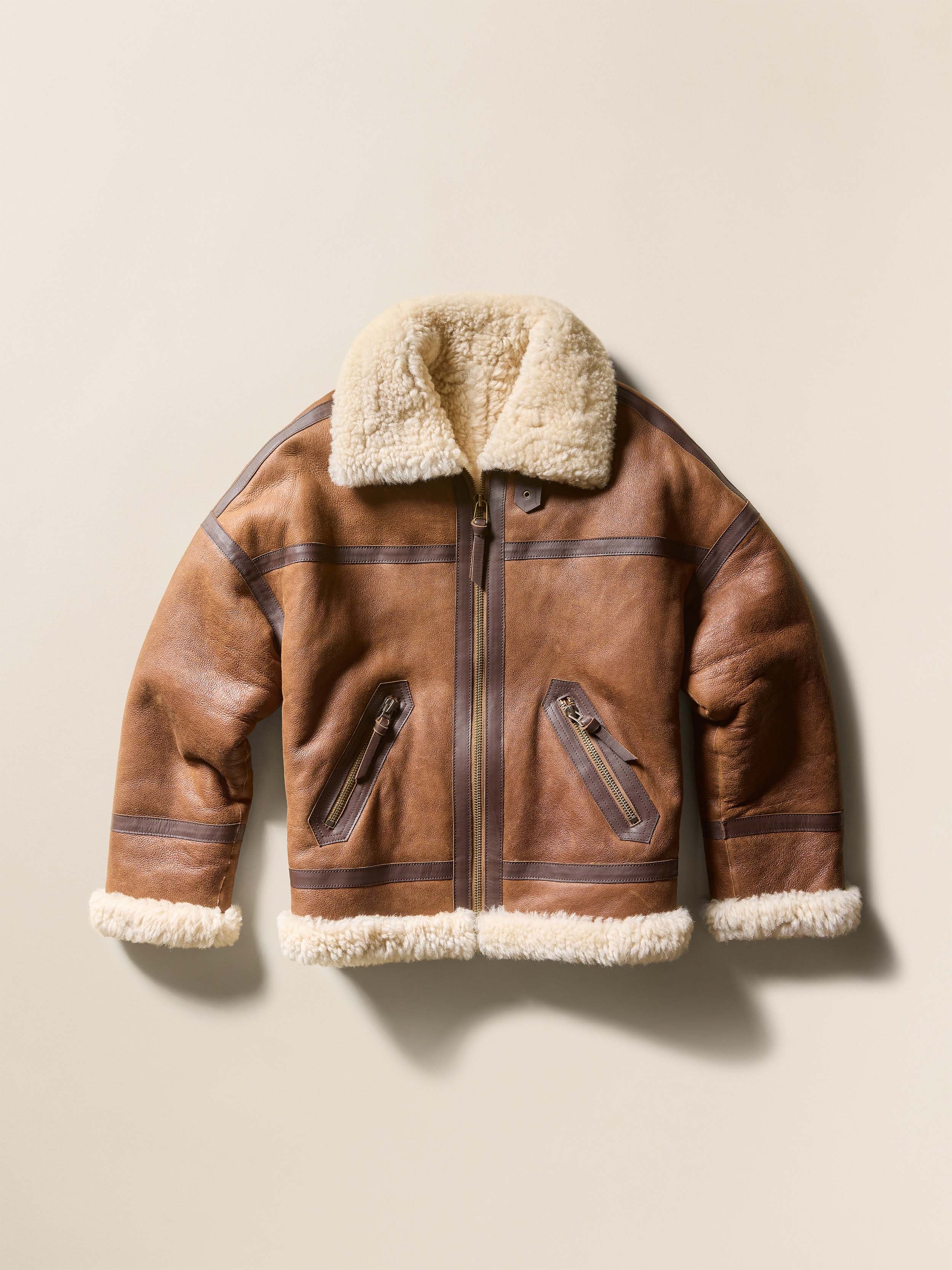 Brown shearling jacket against a beige background