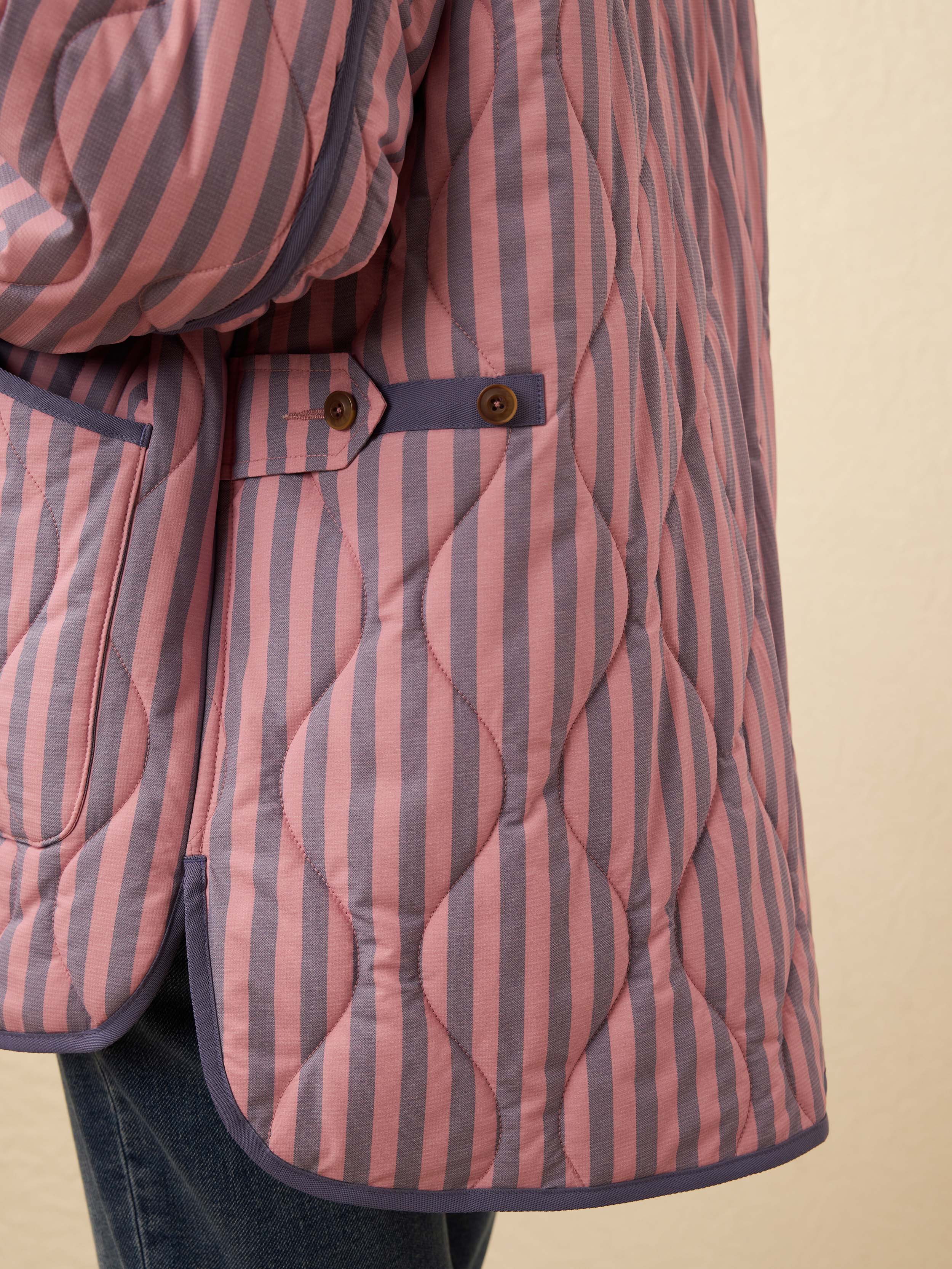 Quilted jacket with pink and blue striped pattern on a beige background