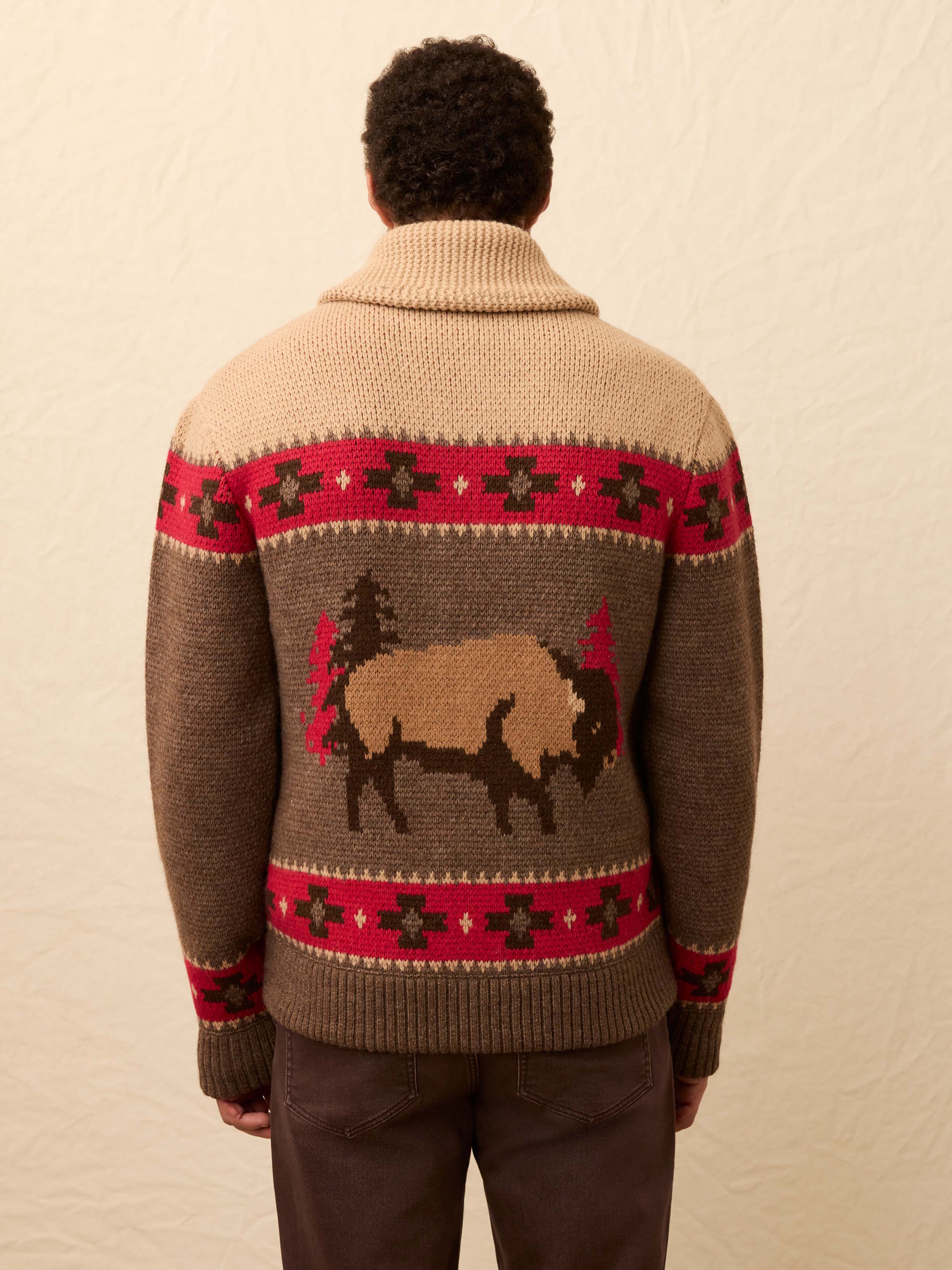 Man wearing a buffalo patterned cardigan against a beige background