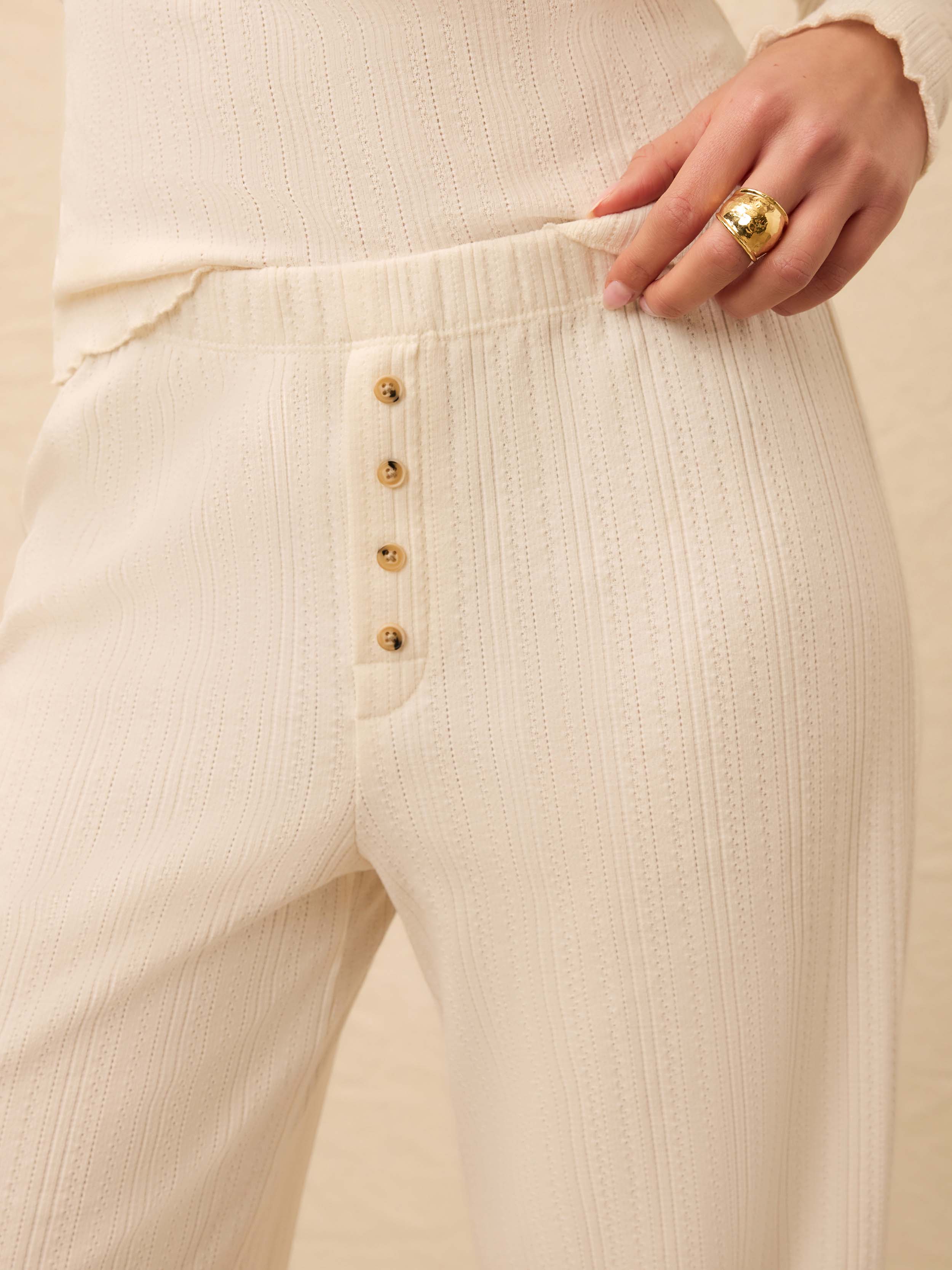 Closeup of white lounge pants with button front detail