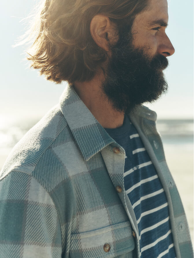Close up of man wearing a legend sweater shirt, with detail on plaid pattern