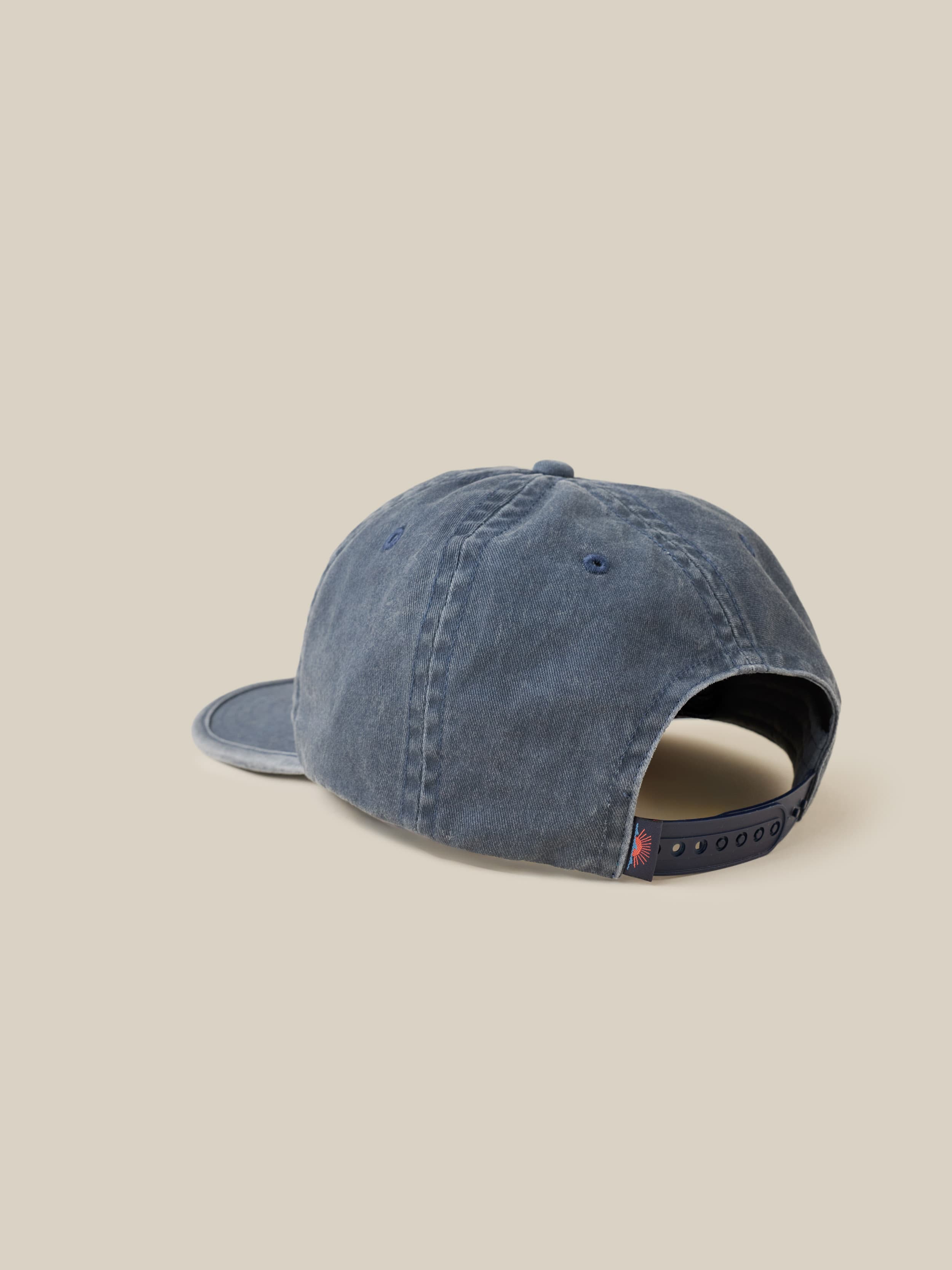 Blue cap with a Faherty label on the back on a beige background
