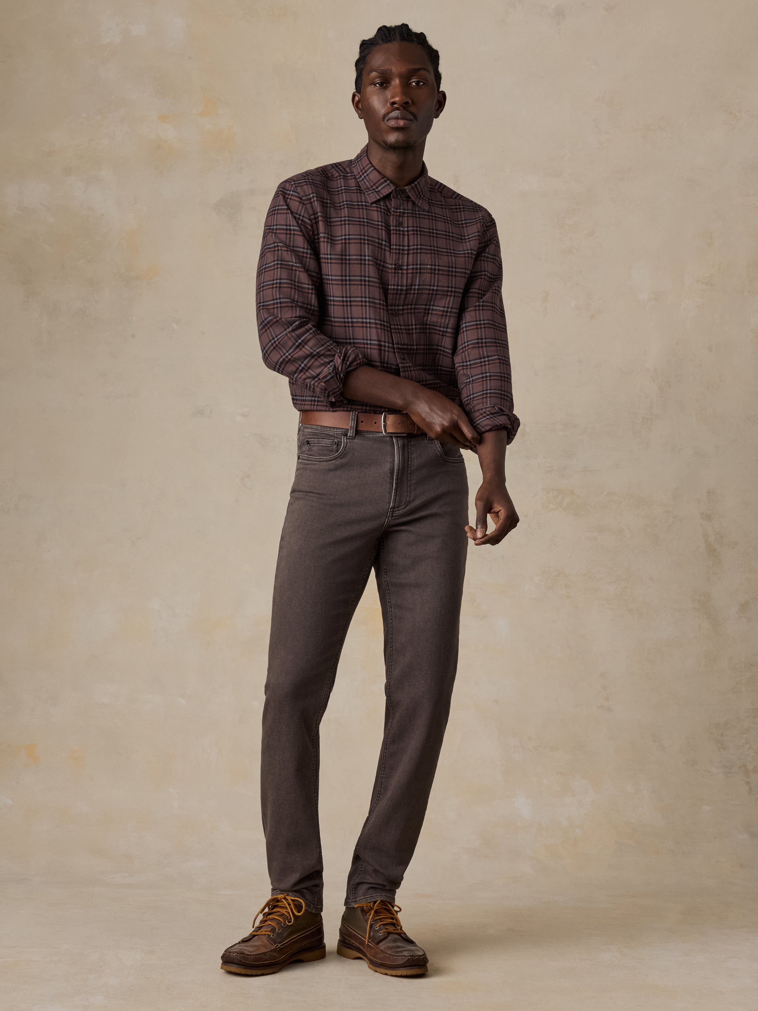 Man wearing a brown plaid shirt and brown pants