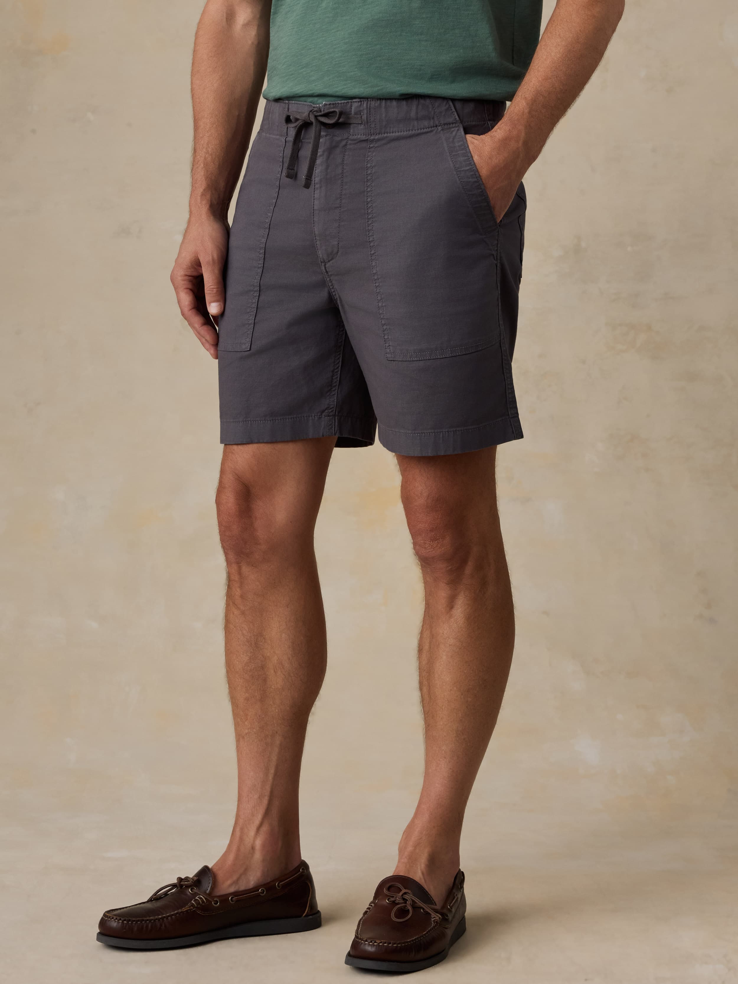 Man wearing black shorts on a beige background