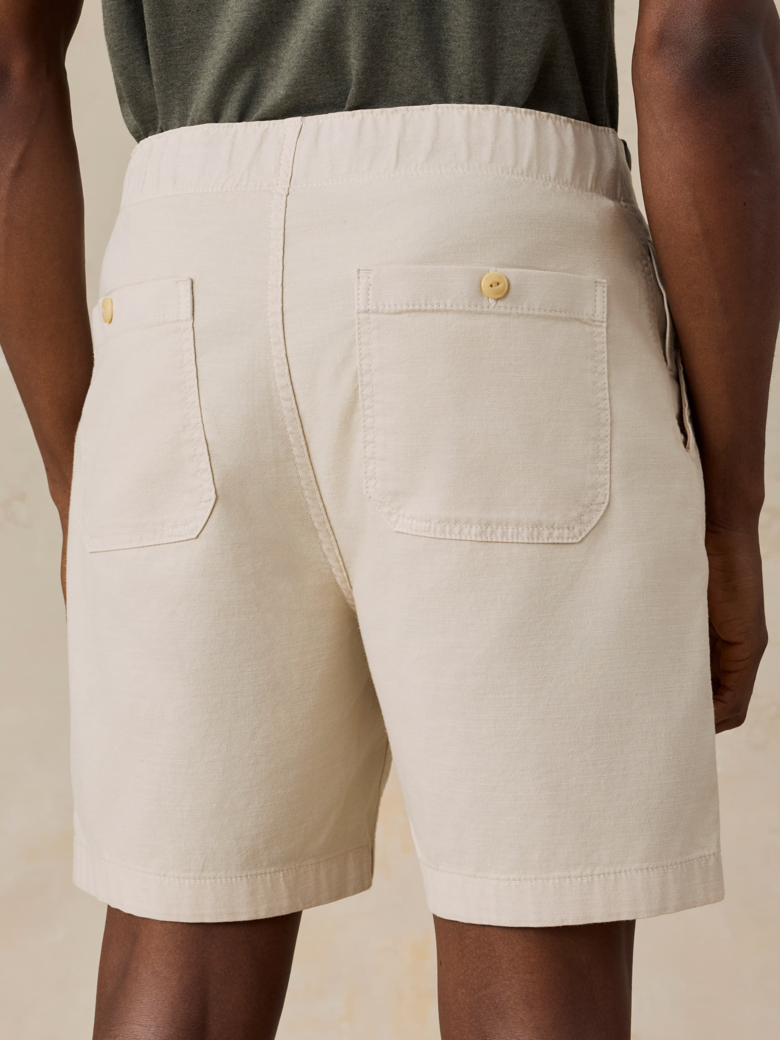 Beige shorts worn by a man against a beige background