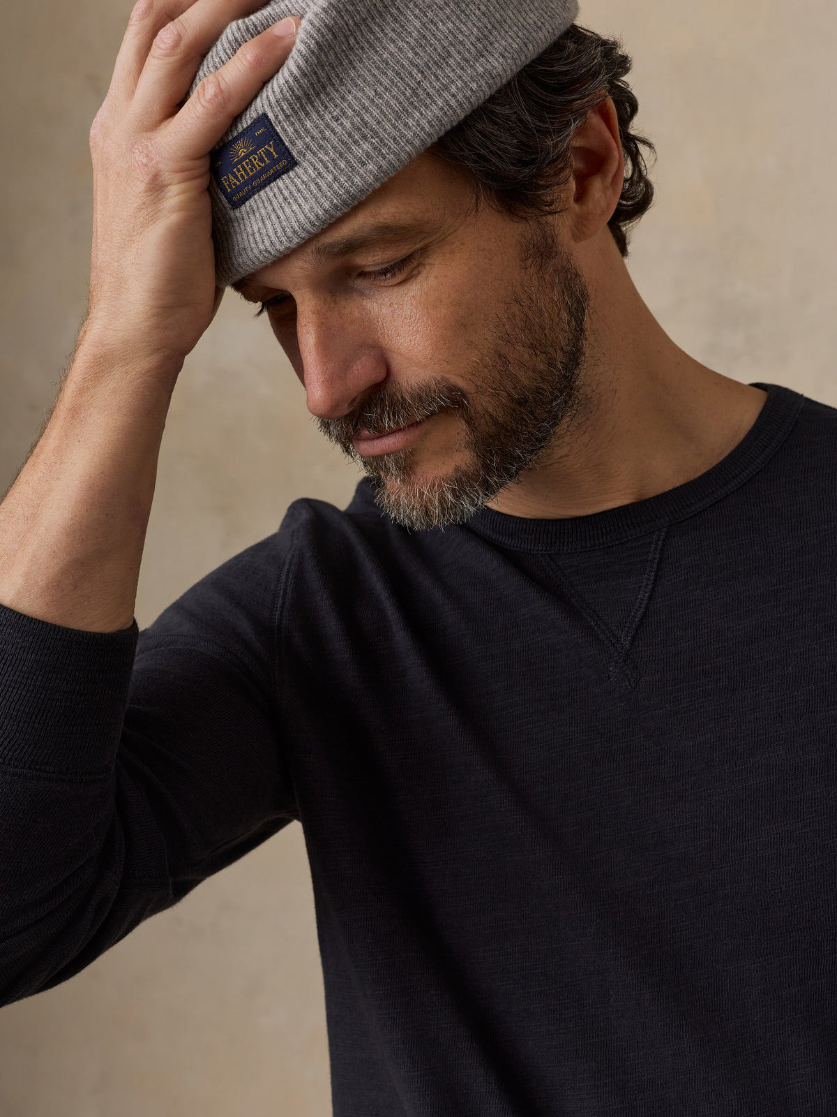 Close up of a man wearing a black crewneck and a beanie, image 3 of 6