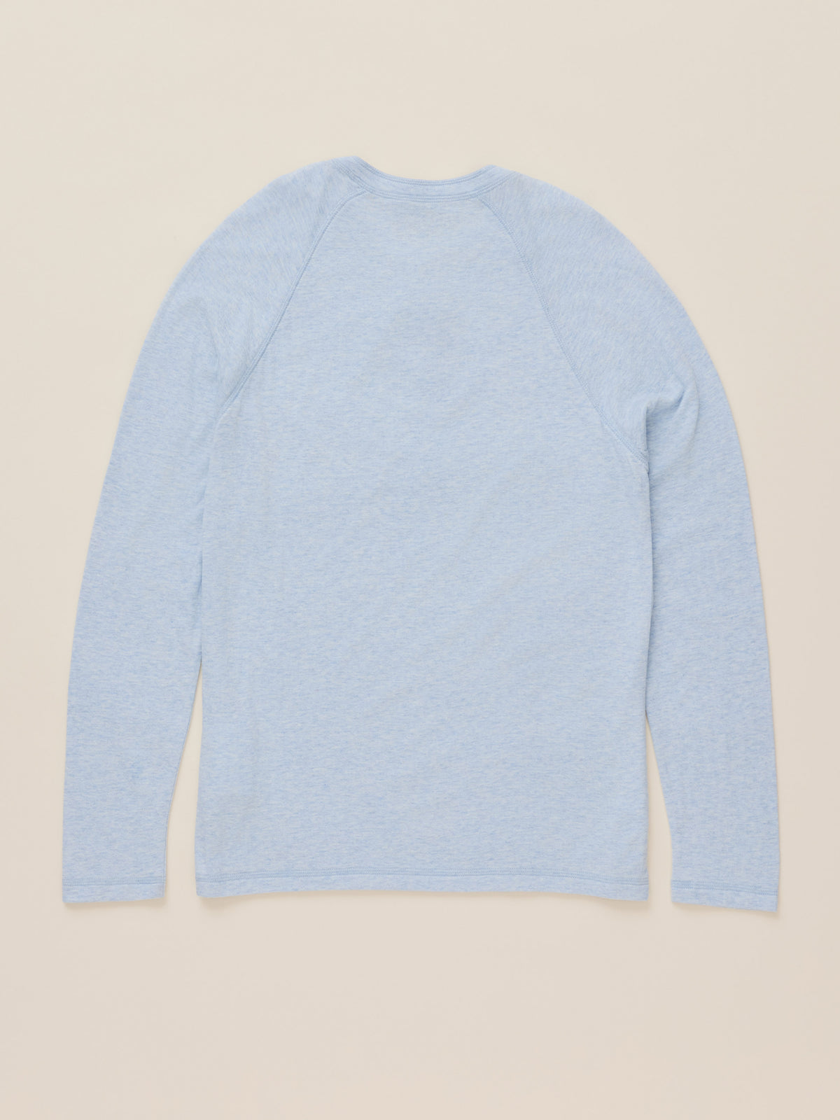 A light blue long-sleeve raglan t-shirt shown from the back, laid flat against a solid beige background., image 9 of 9