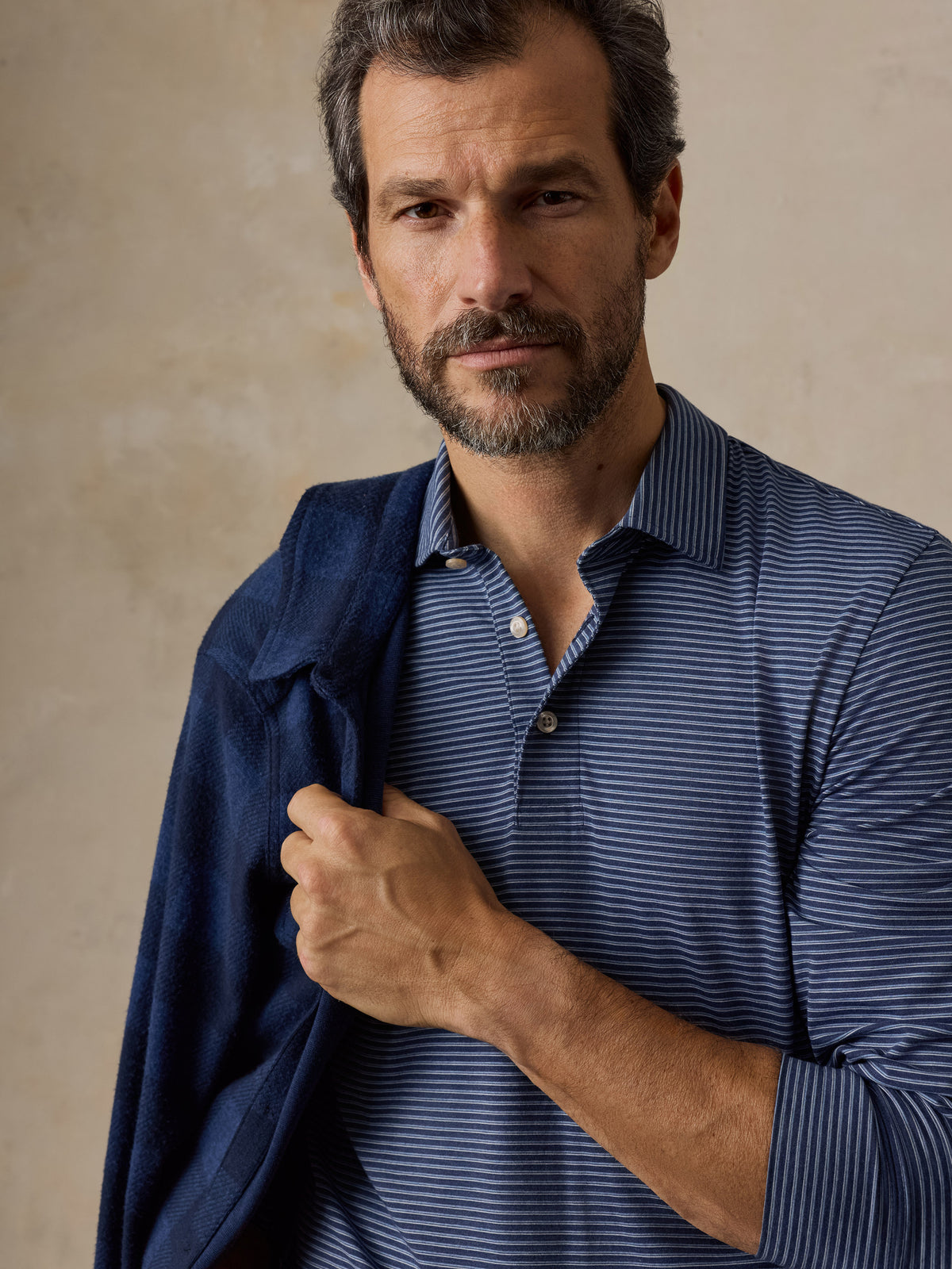 Close up of a man wearing a blue striped polo shirt , image 3 of 5