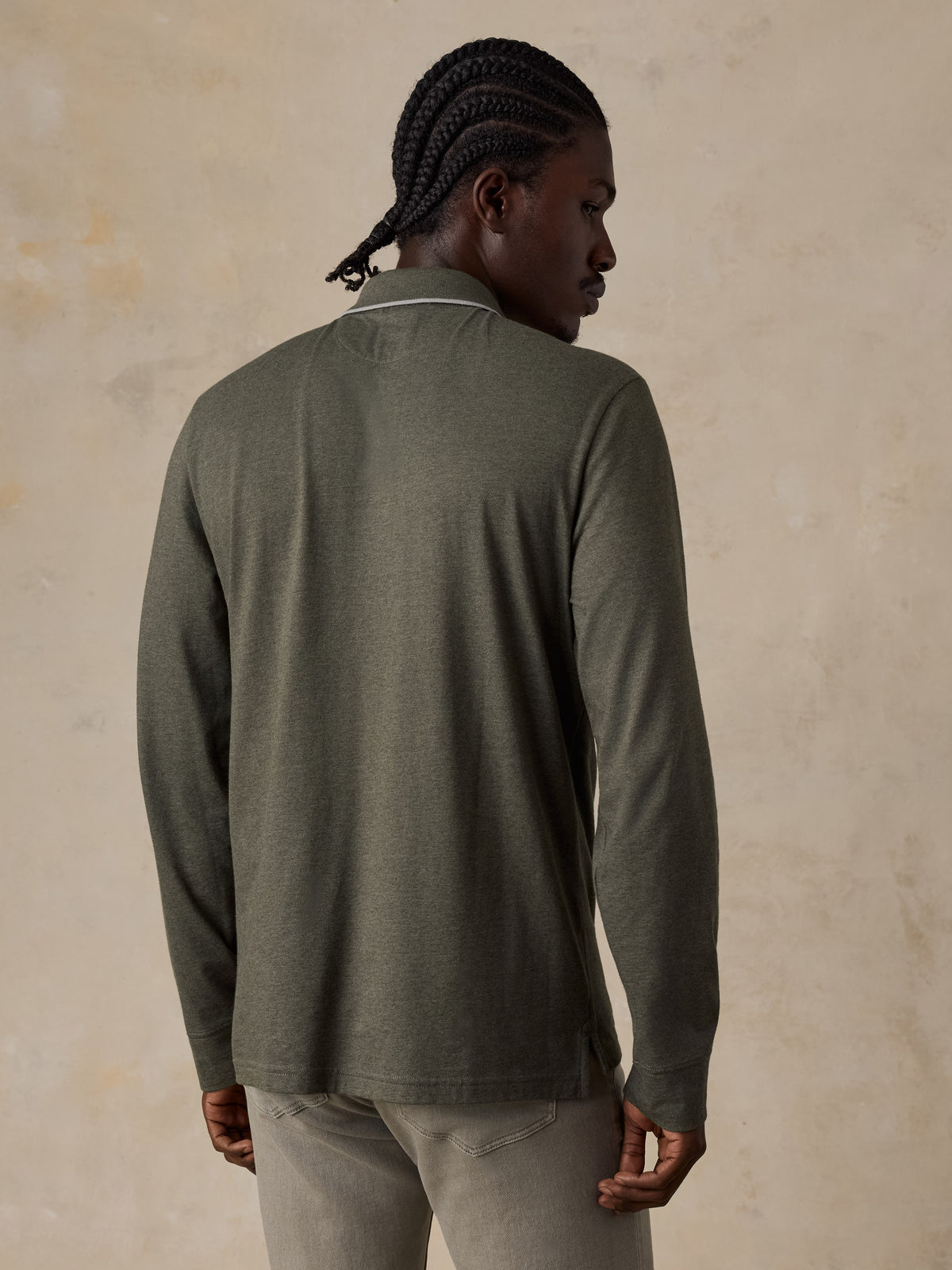 A man viewed from the back wearing a green long sleeve polo with green pants, image 5 of 6