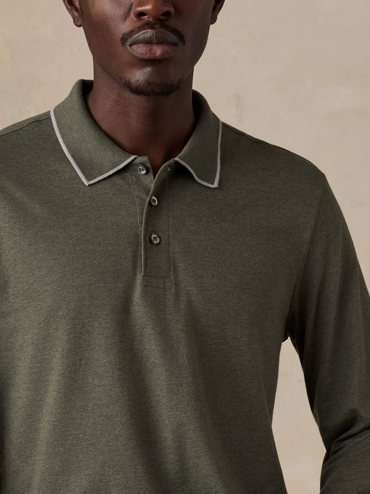 Close up of a man wearing a green long sleeve polo, image 6 of 6
