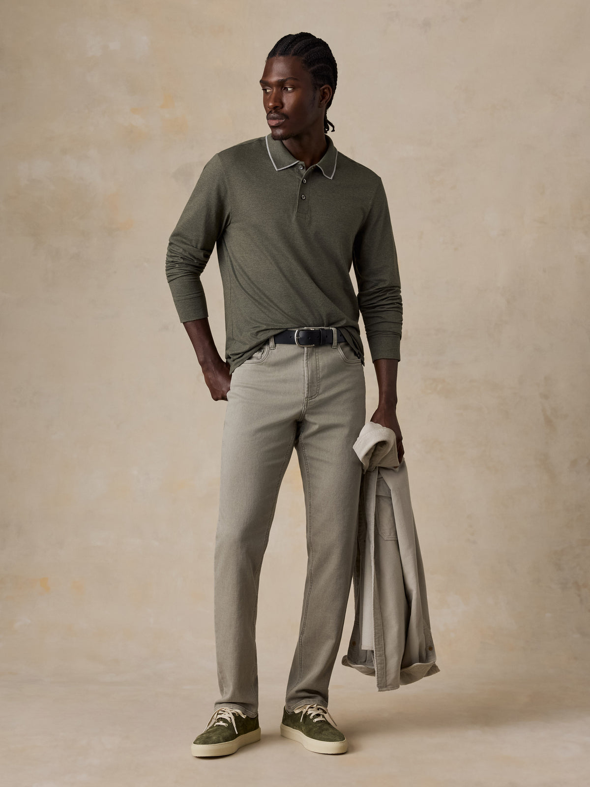 A man wearing a green long sleeve polo, green pants, and green sneakers, image 1 of 6
