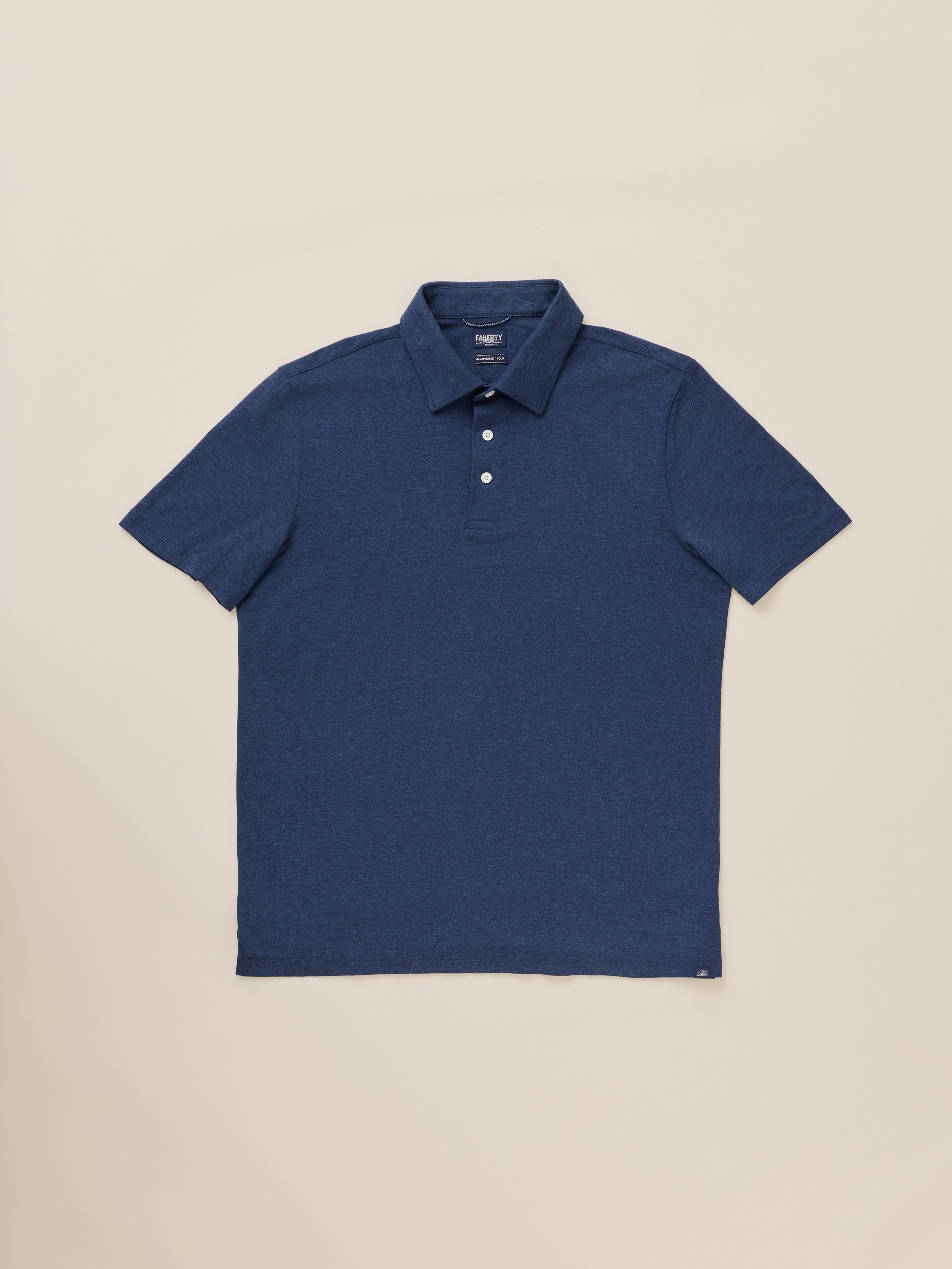 A blue short-sleeve polo shirt against a warm beige studio background