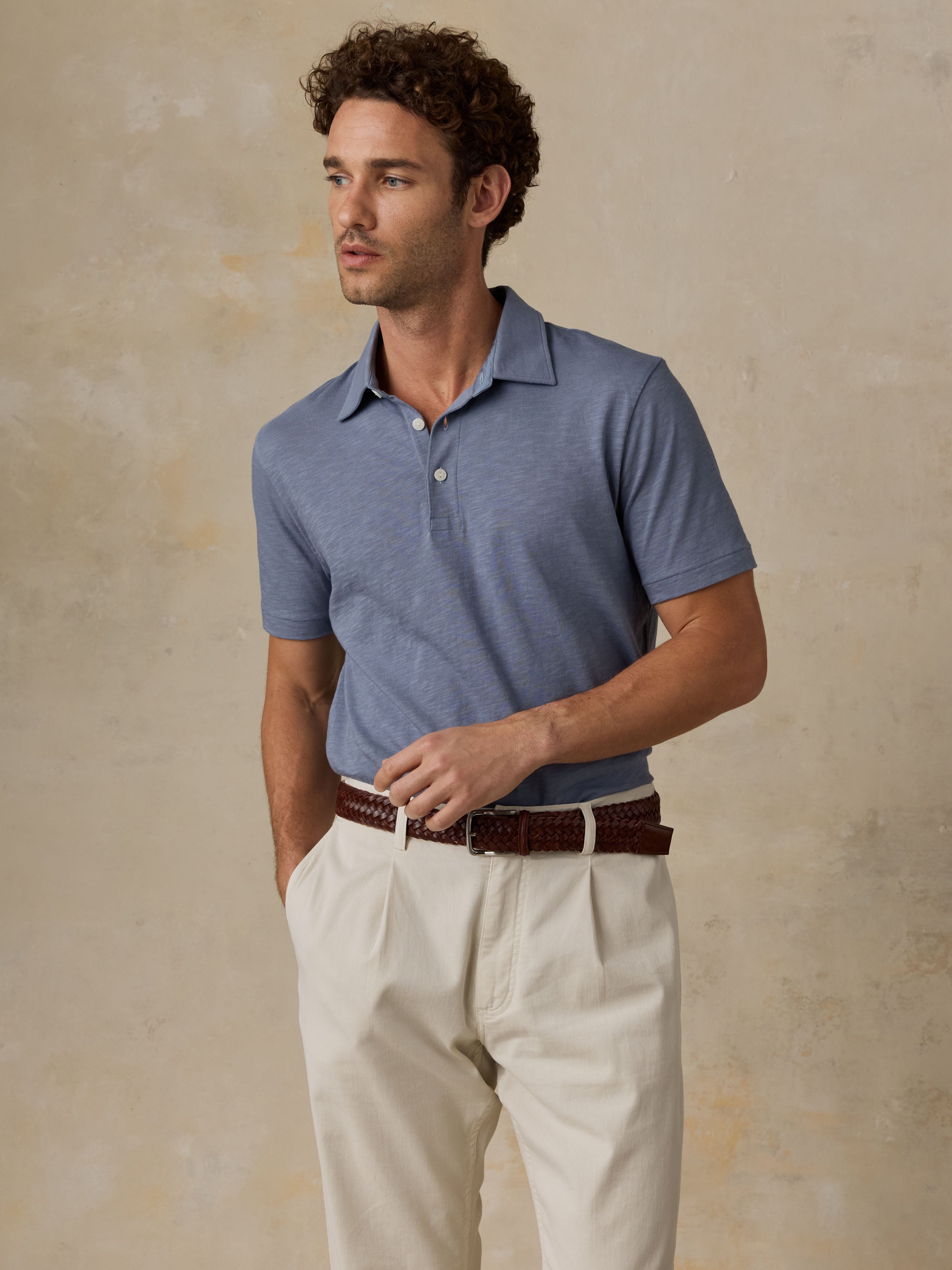 grey dress shirt with khaki pants A Man in a Grey Shirt and Khaki Pants Sits on a Curb Stock Image