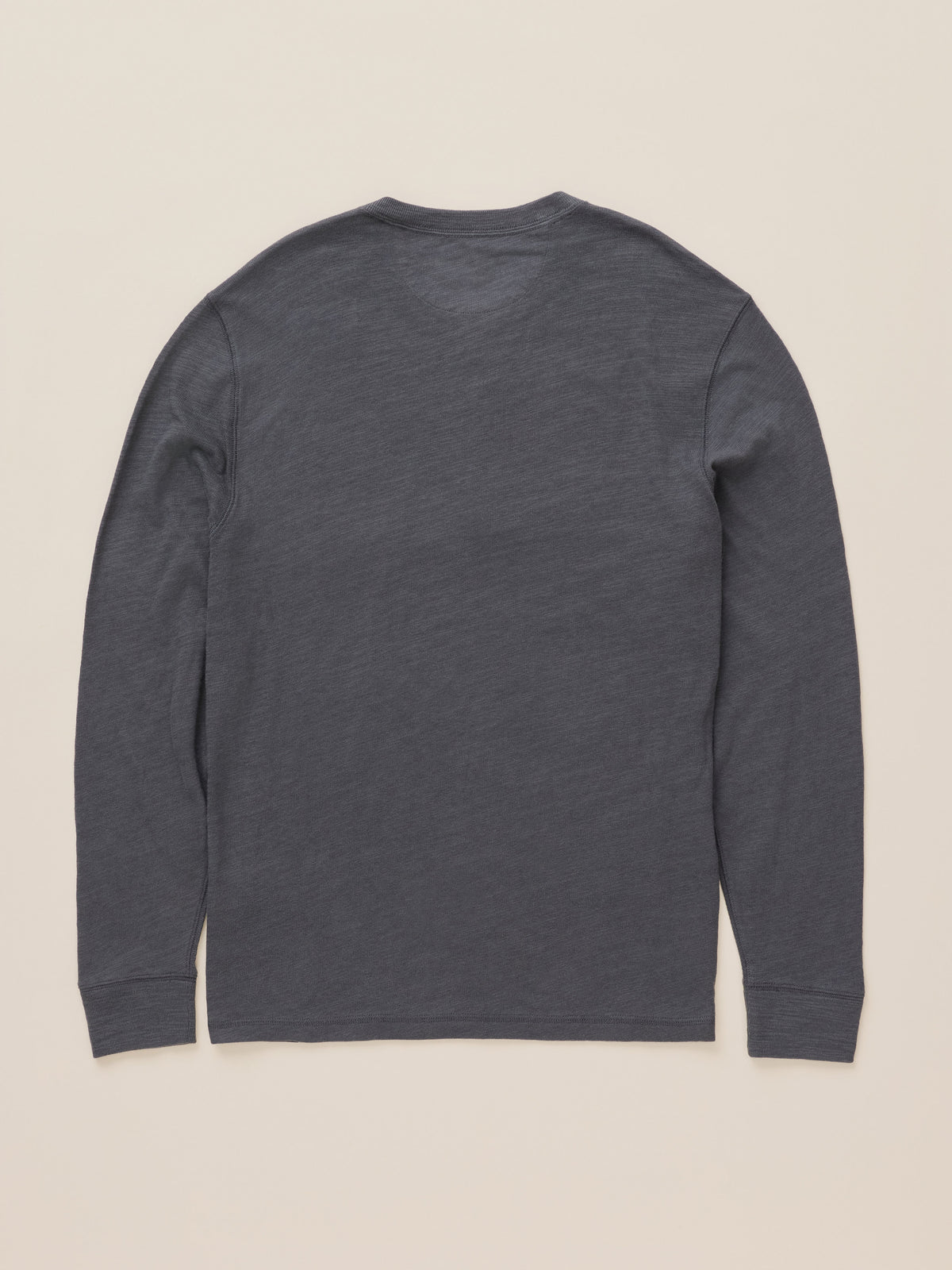 A dark gray long-sleeve shirt shown from the back, laid flat against a light beige background.
