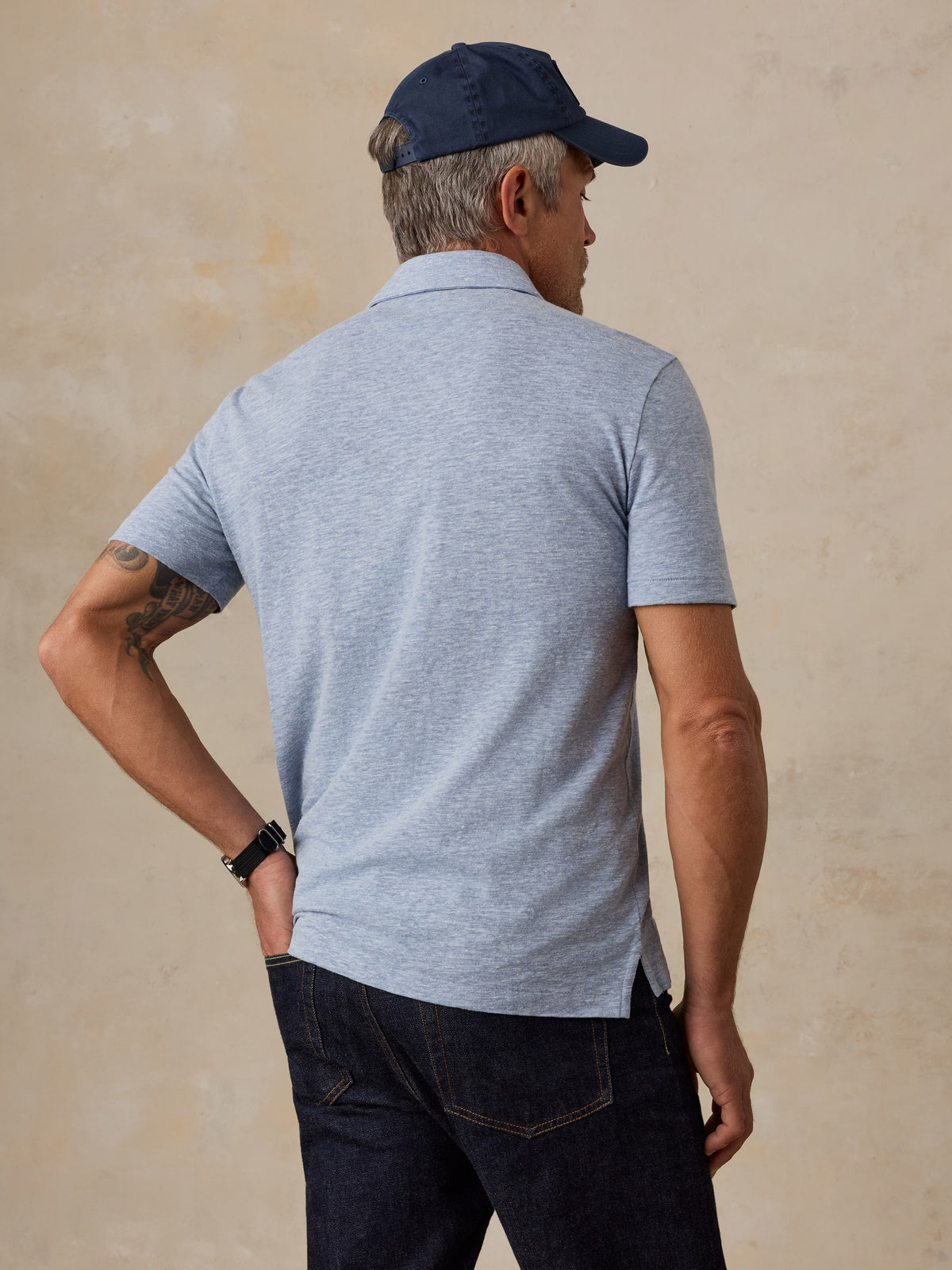A man viewed from behind wearing a light blue polo, image 5 of 5
