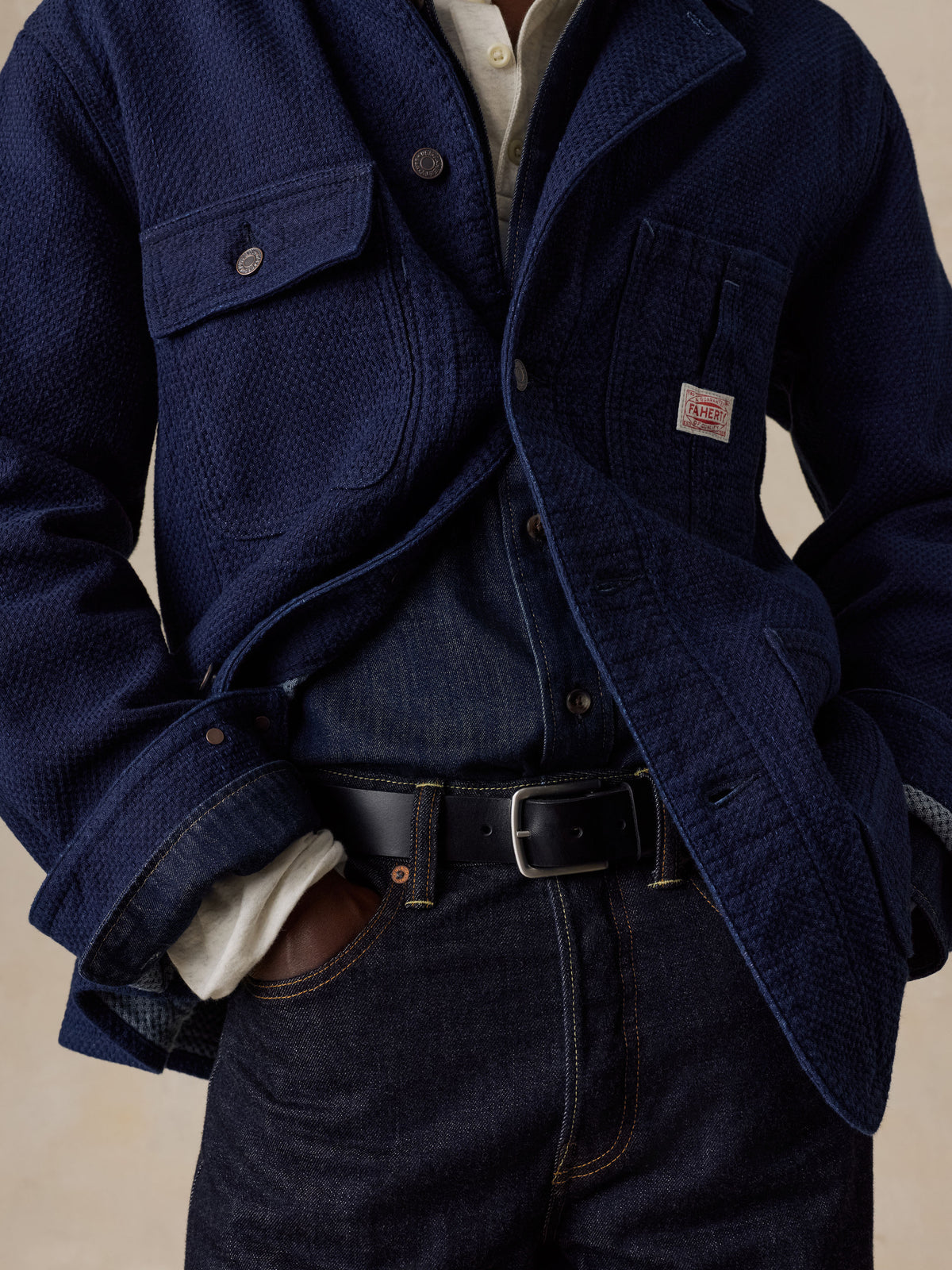Close up of a man wearing a blue jacket over a denim shirt and blue jeans, image 4 of 6