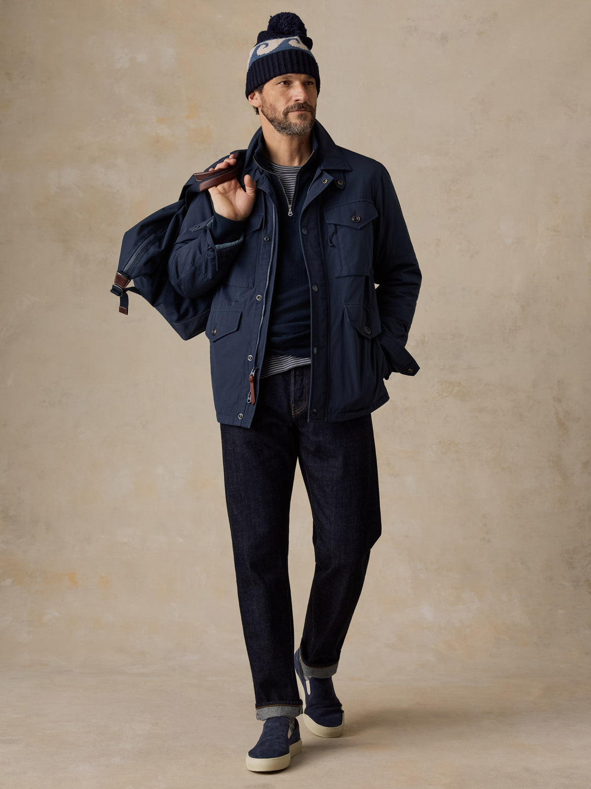 A man wearing a blue jacket, blue jeans, and blue sneakers, image 2 of 5
