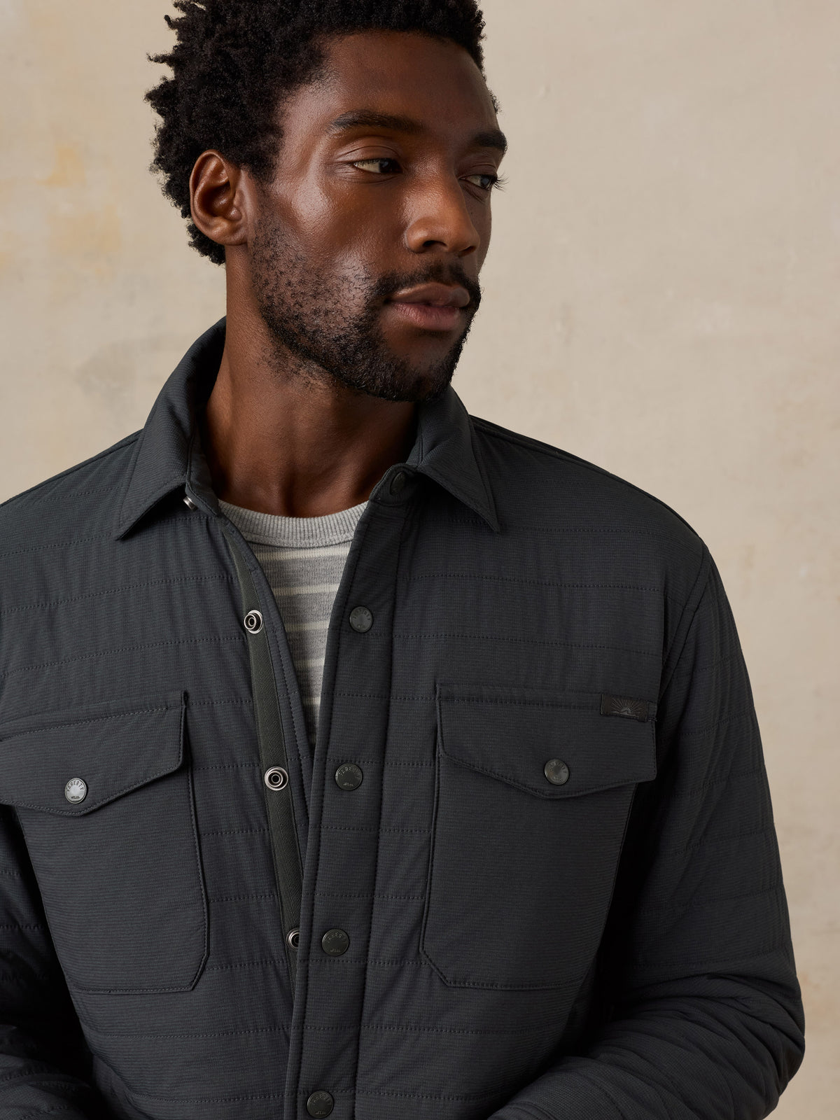 A close up of a man wearing a black jacket and jeans, image 3 of 4