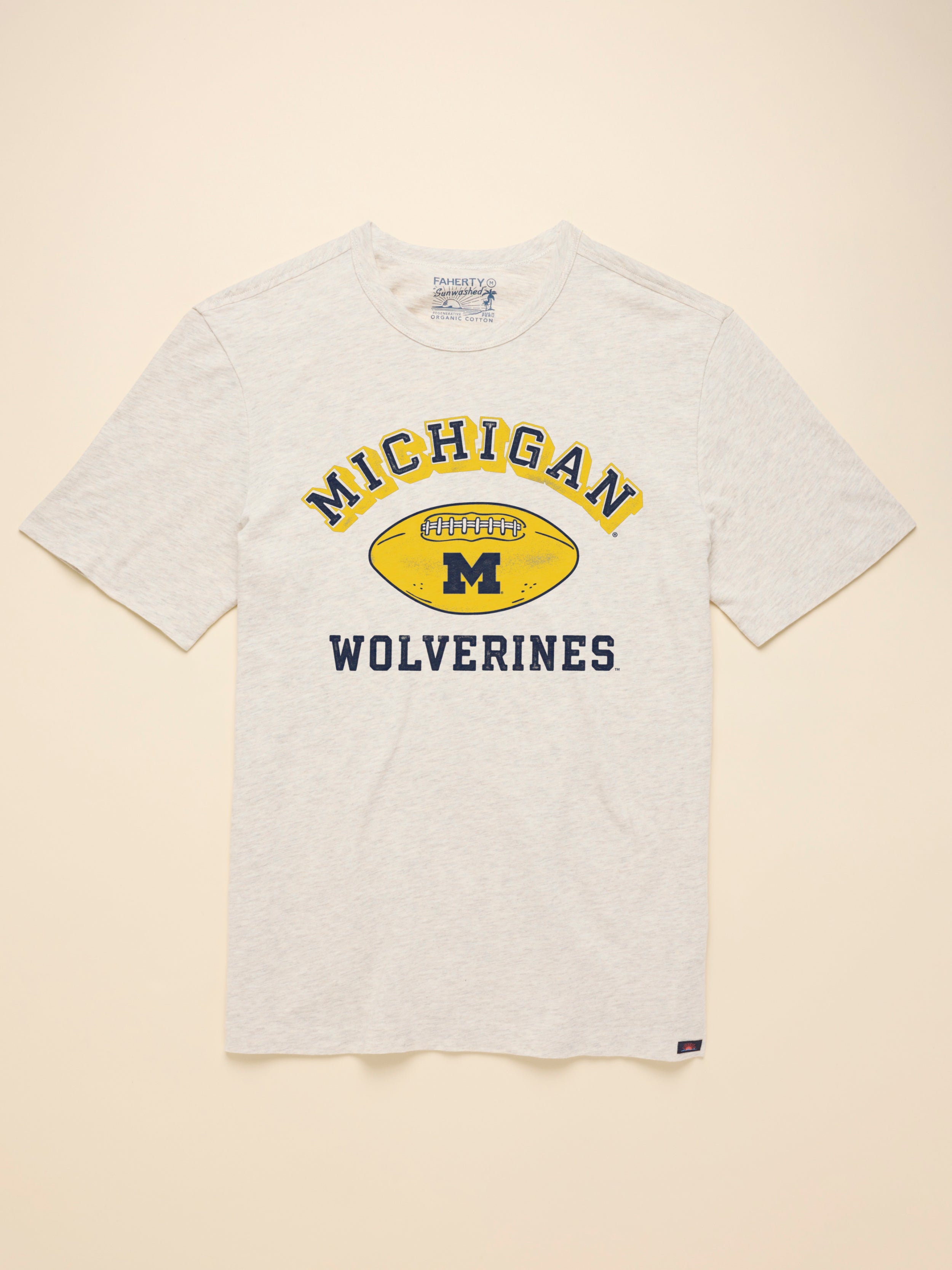 Grey short sleeve t-shirt with University of Michigan graphic at the center chest against a beige background