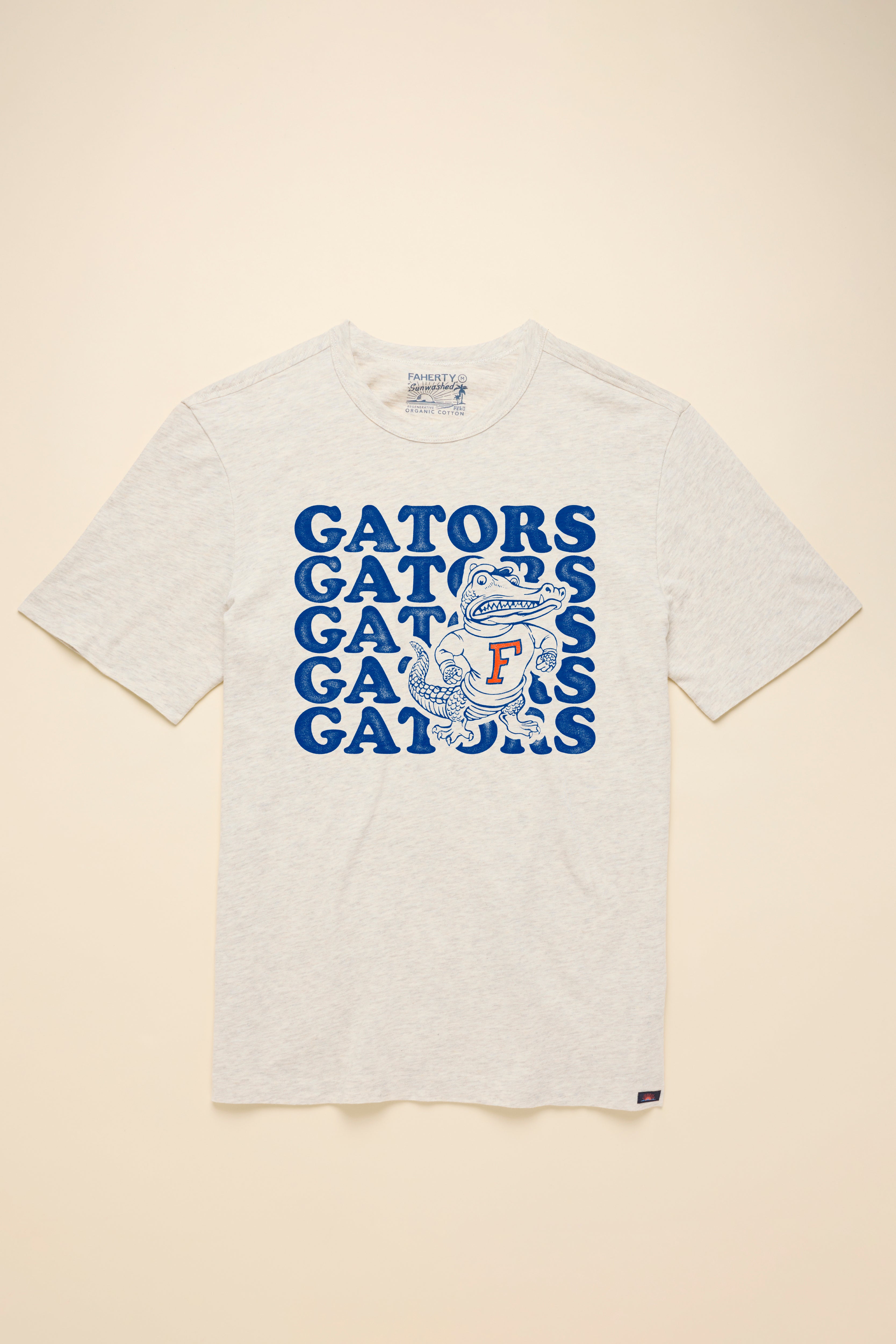 A white short-sleeve t-shirt with University of Florida graphic at the center front against a beige background