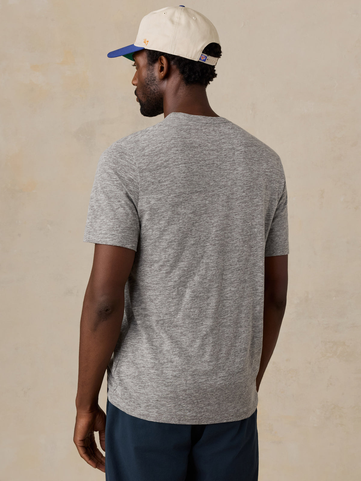 A man viewed from behind wearing a grey NY Knicks tee, image 2 of 6
