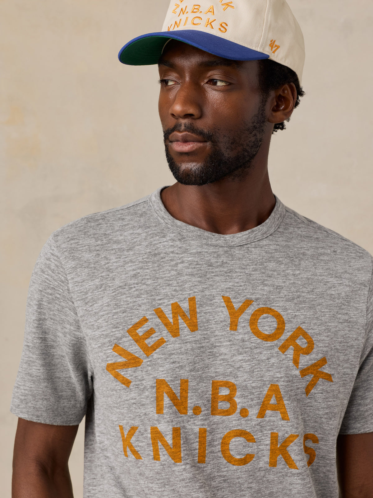 Close up of a man wearing a grey NY Knicks tee, image 3 of 6