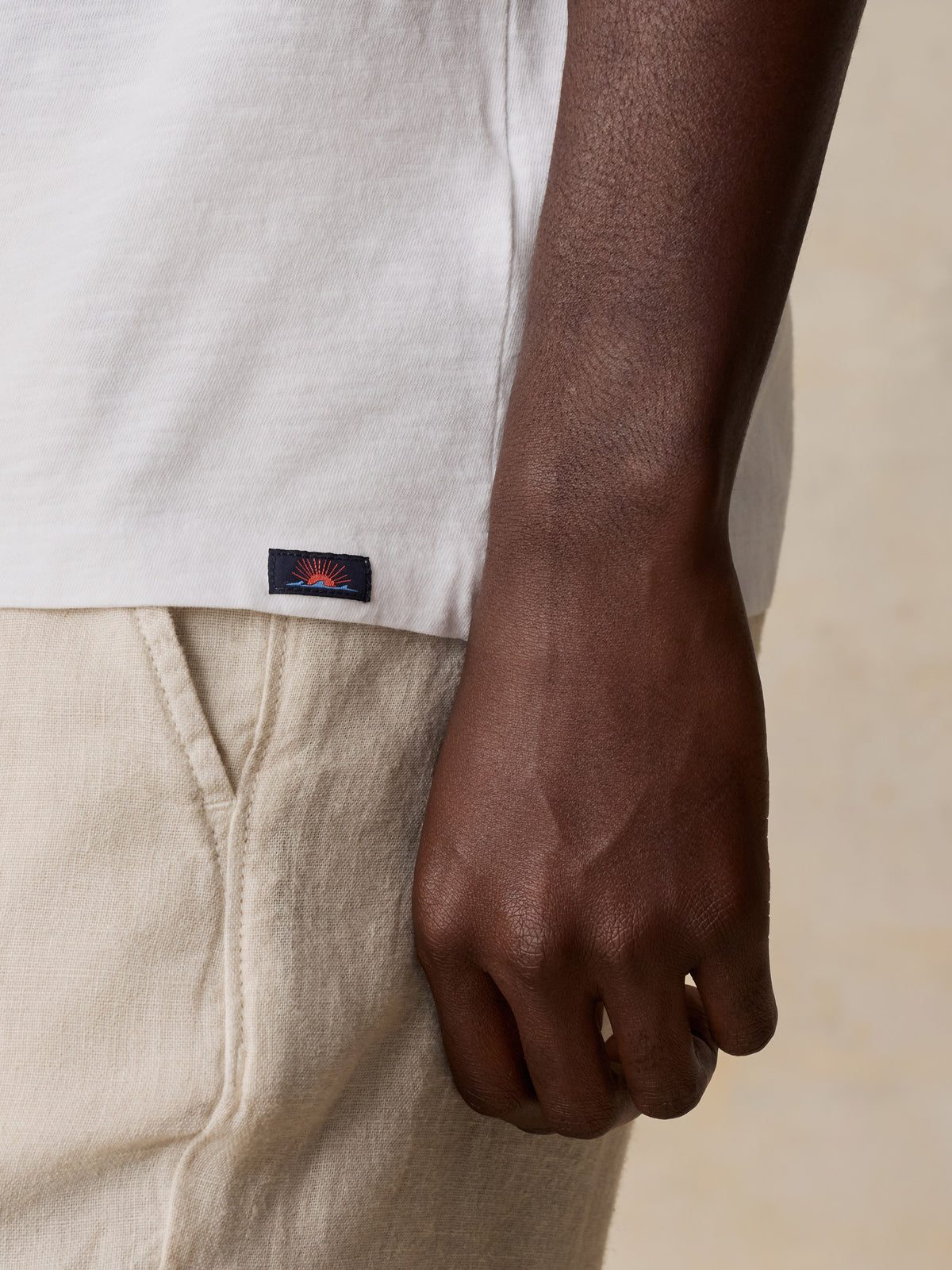 Close up of a man wearing a white LA Lakers tee and linen pants, image 4 of 6