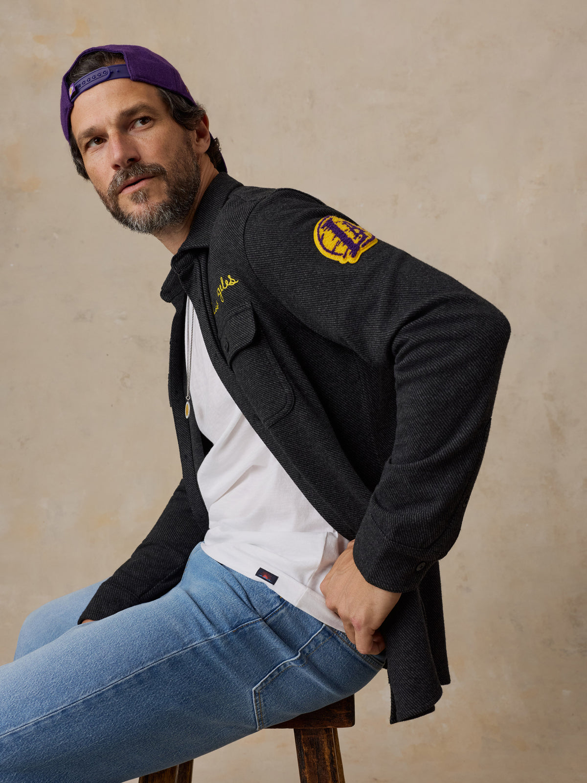 A man wearing a black LA Lakers shirt and blue jeans, image 5 of 6