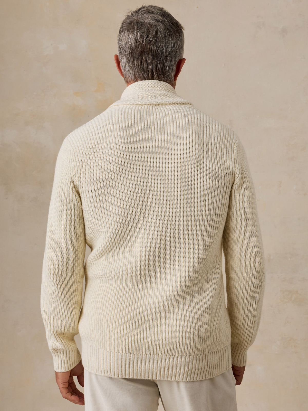 A man viewed from behind wearing an off-white LA Lakers cardigan and white pants, image 2 of 7