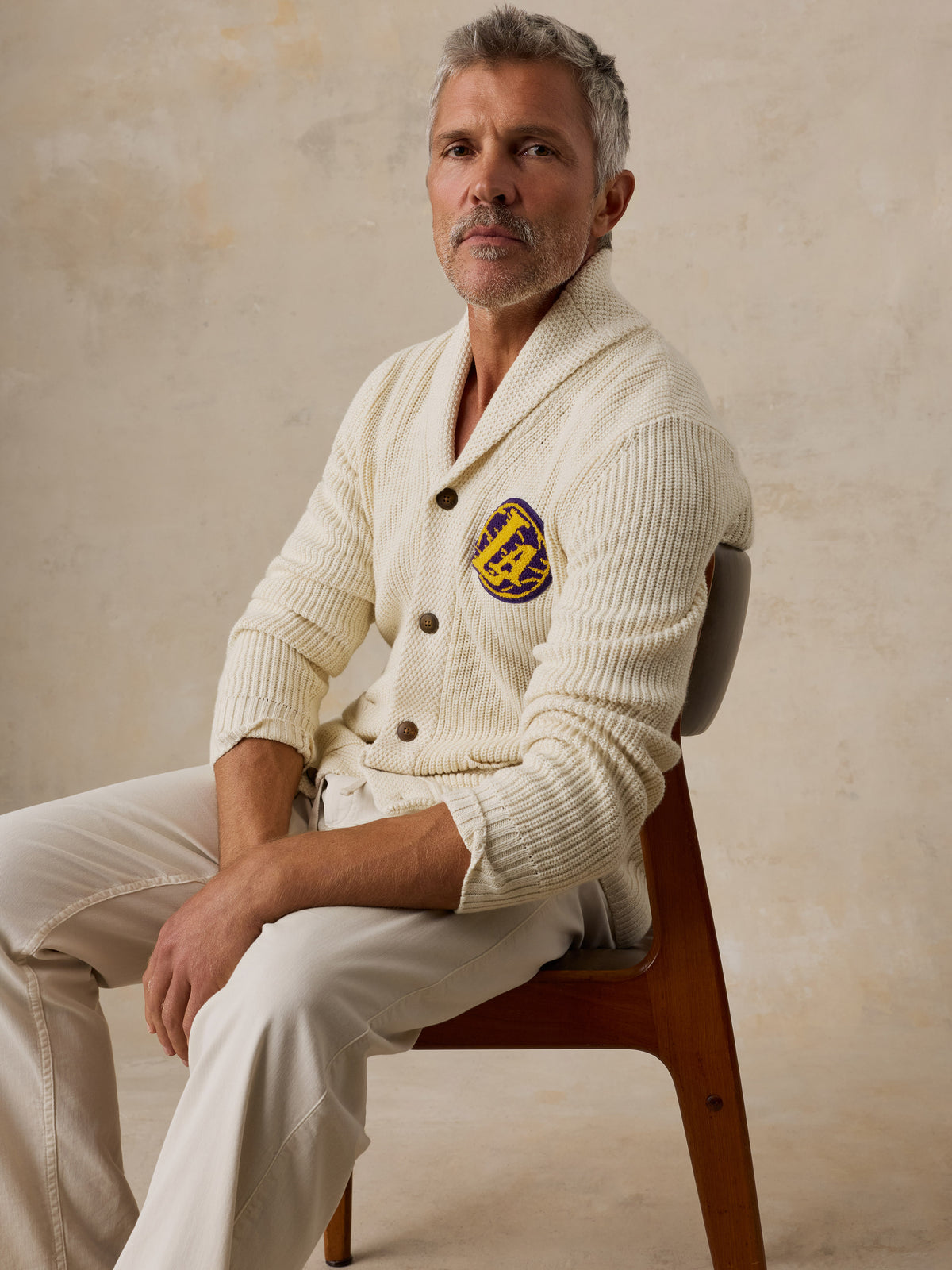 A man wearing an off-white LA Lakers cardigan and white pants, image 5 of 7
