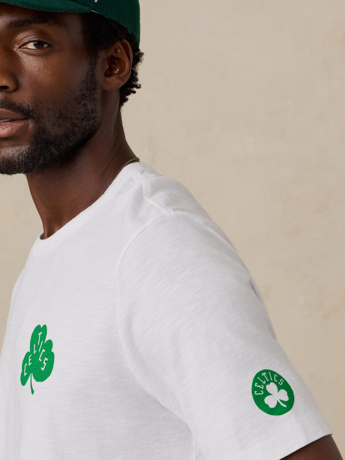 Close up of a man wearing a white Boston Celtics tee, image 4 of 6