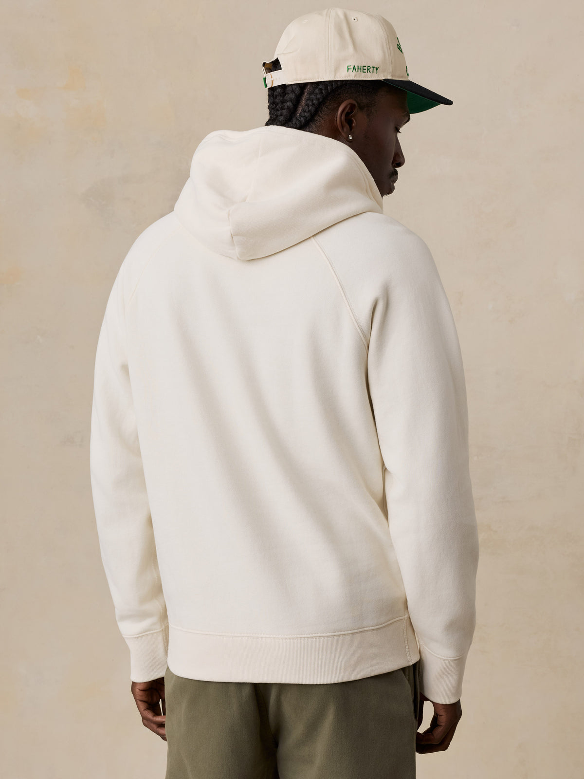 A man viewed from the back wearing a white Boston Celtics hoodie, image 5 of 6
