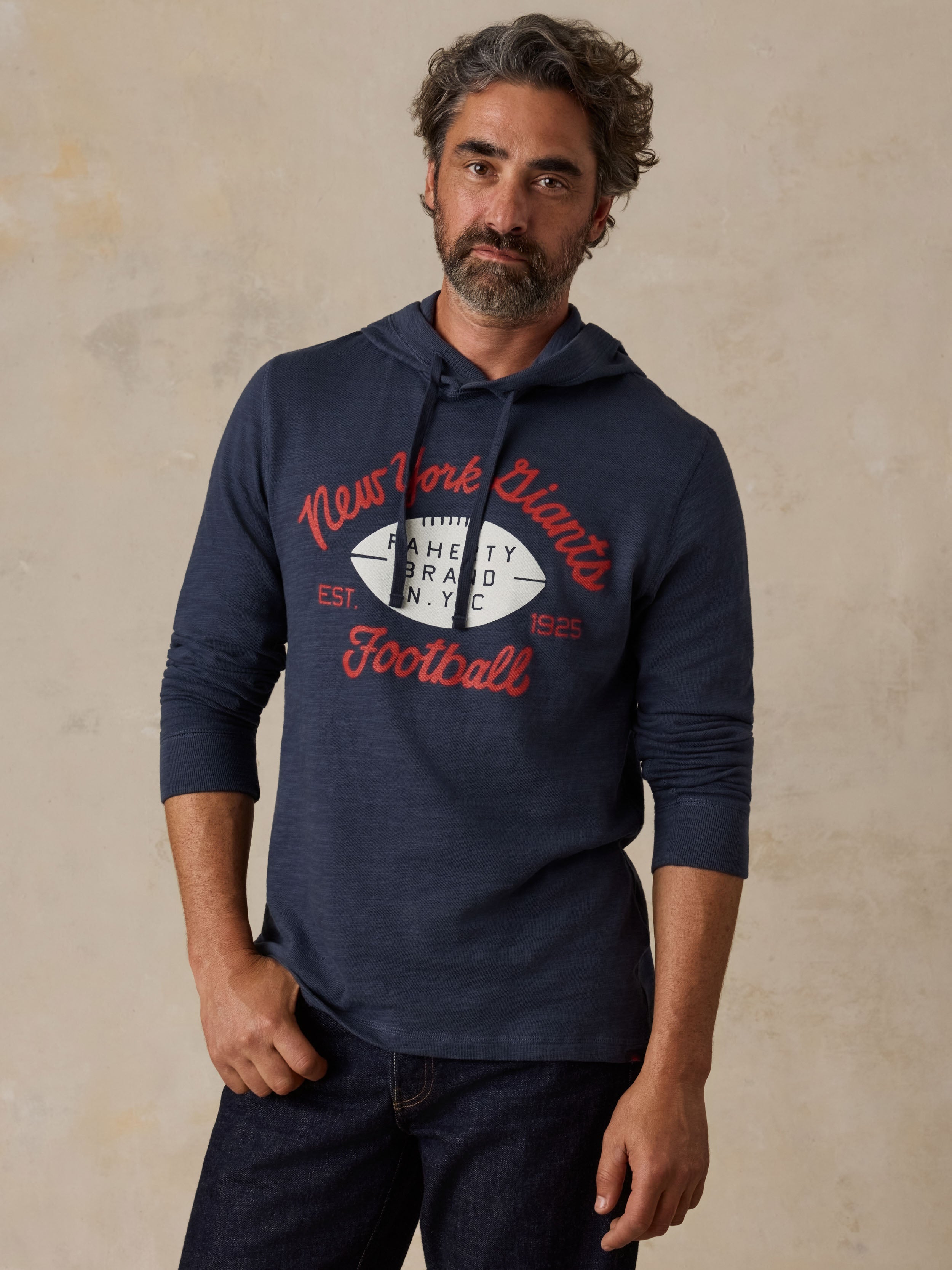 Man wearing a navy NY Giants hoodie and blue jeans