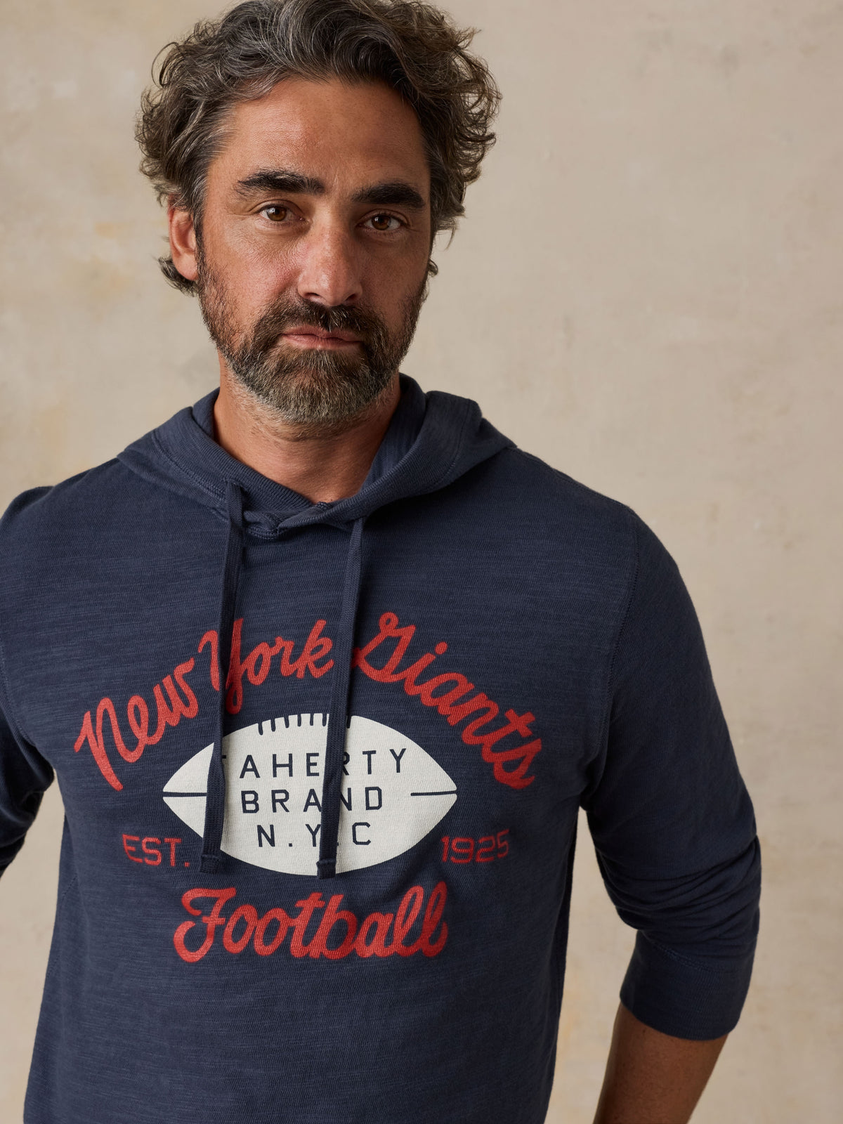 Man wearing a navy NY Giants hoodie, image 3 of 6