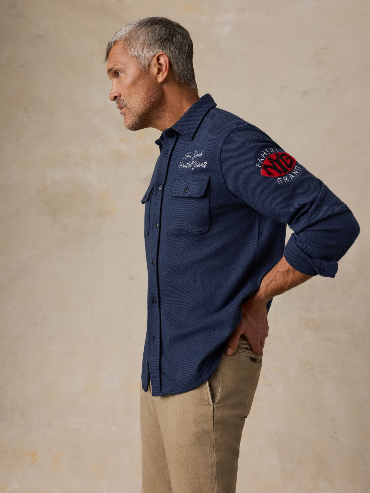 Man wearing a NY Giants button up shirt and beige pants, image 7 of 7