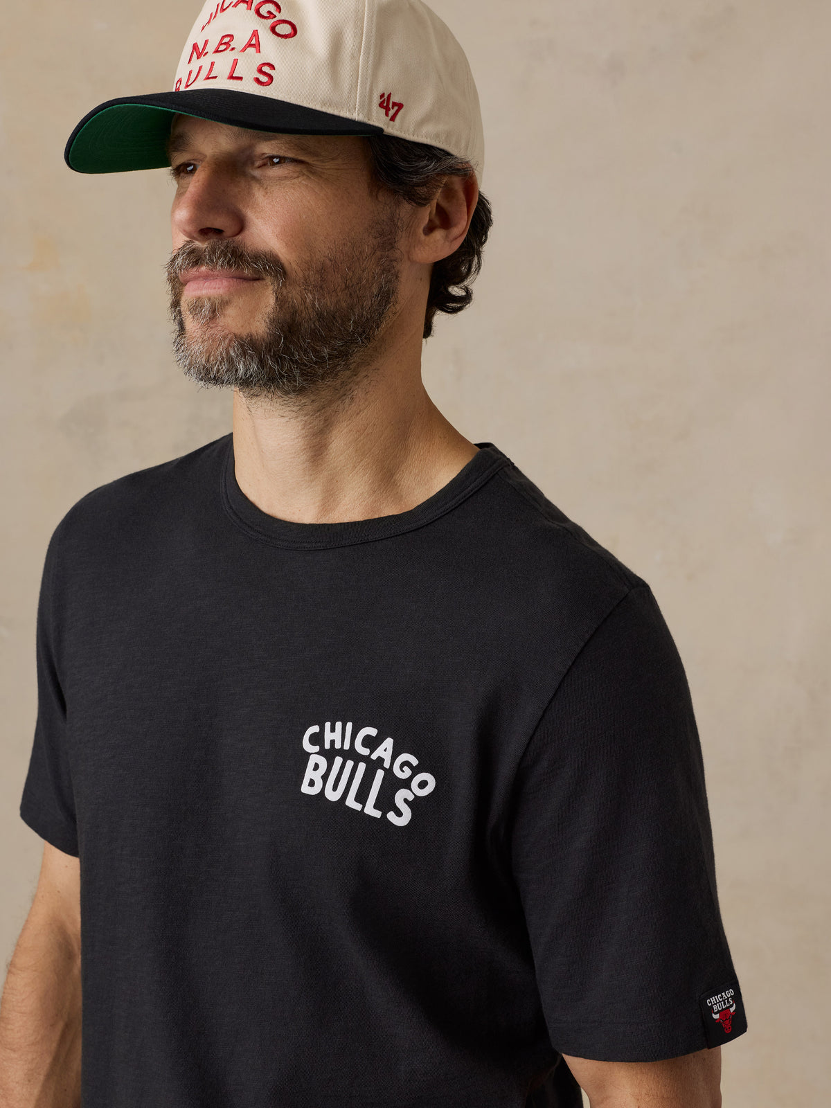 A man wearing a black Chicago bulls tee and hat, image 4 of 6