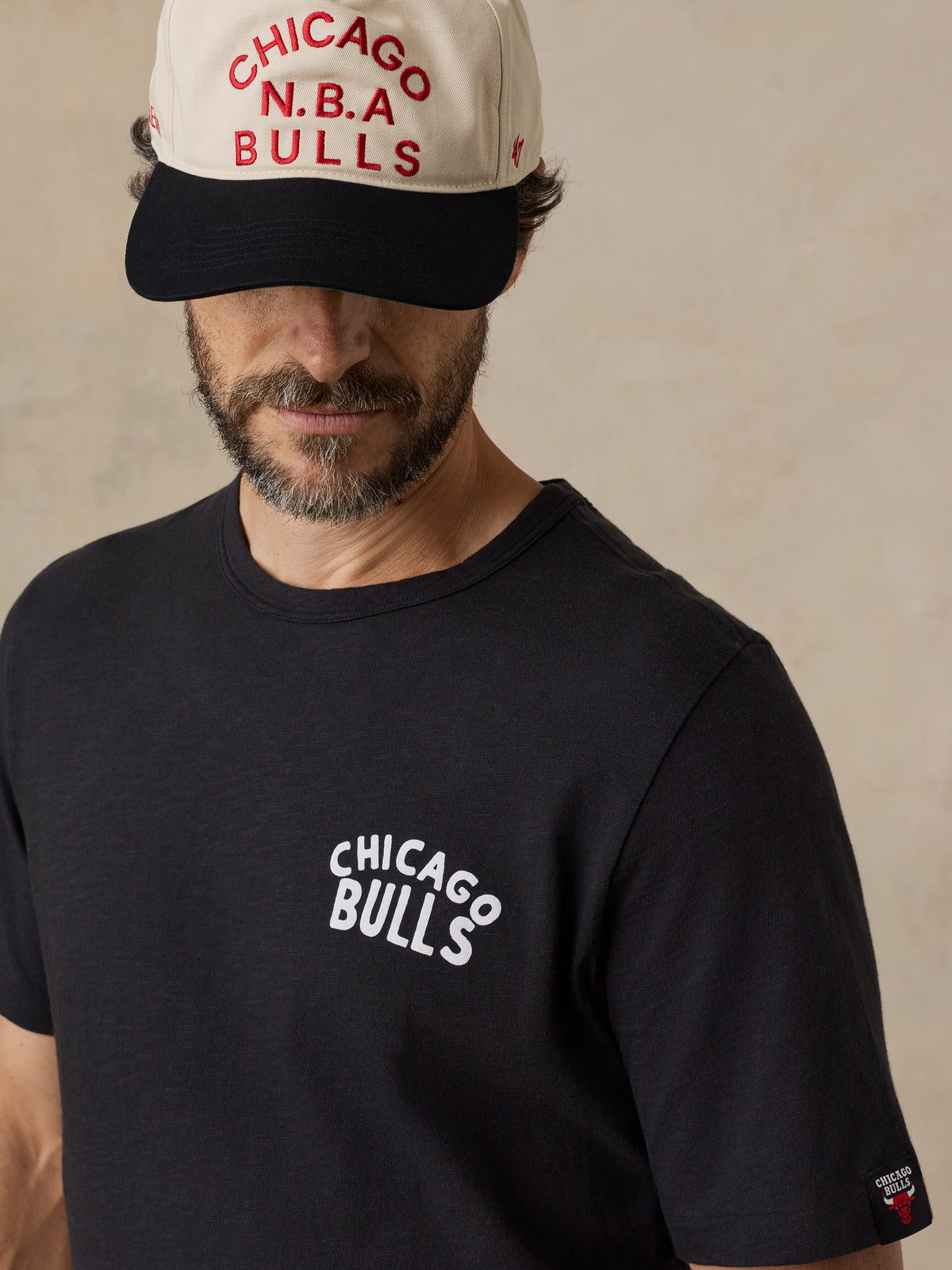 A man wearing a black Chicago bulls tee and hat, image 5 of 6