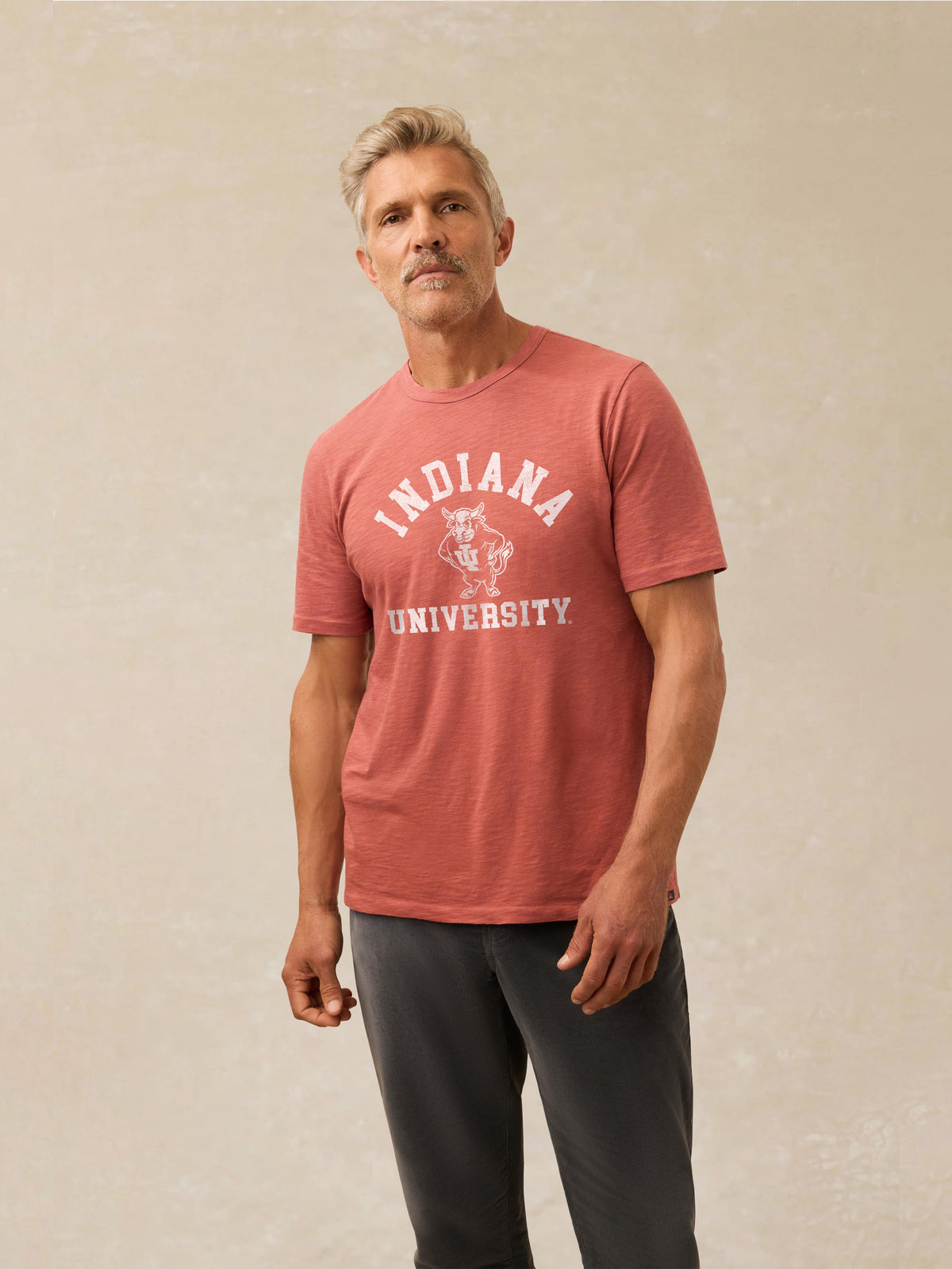 A man wearing a red Indiana University tee and black sweatpants, image 1 of 1