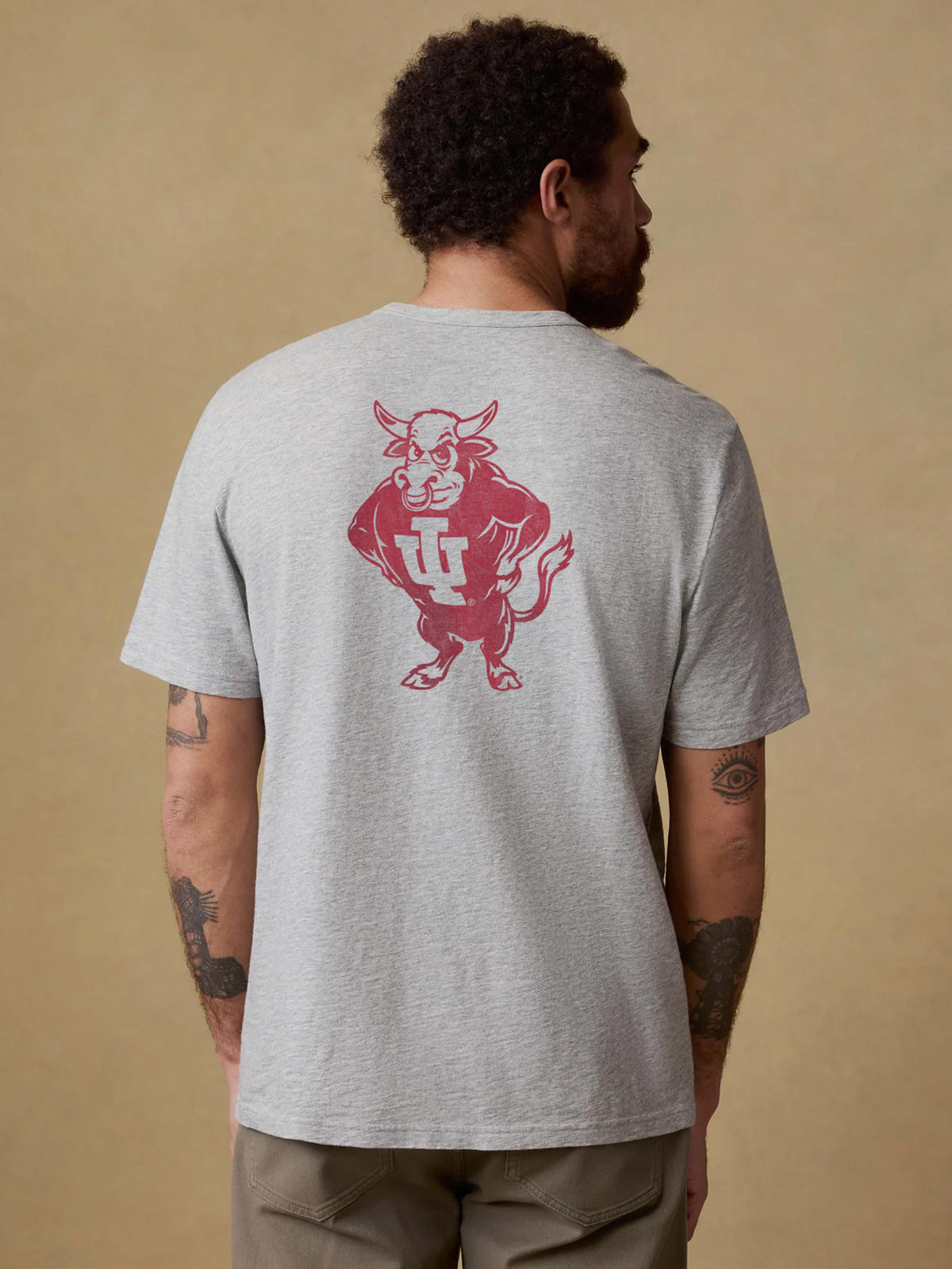 A man viewed from behind wearing a grey Indiana tee and brown pants, image 2 of 2