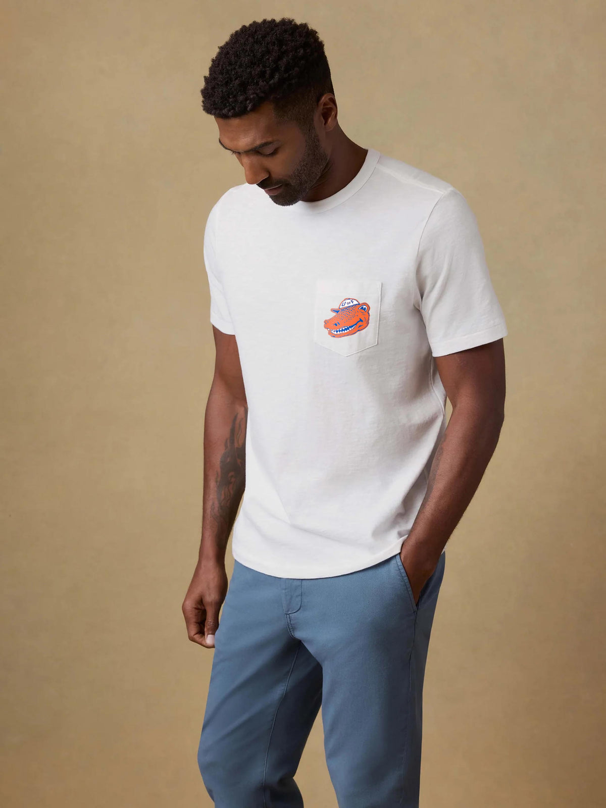 A man wearing a University of Florida tee and blue pants, image 1 of 2
