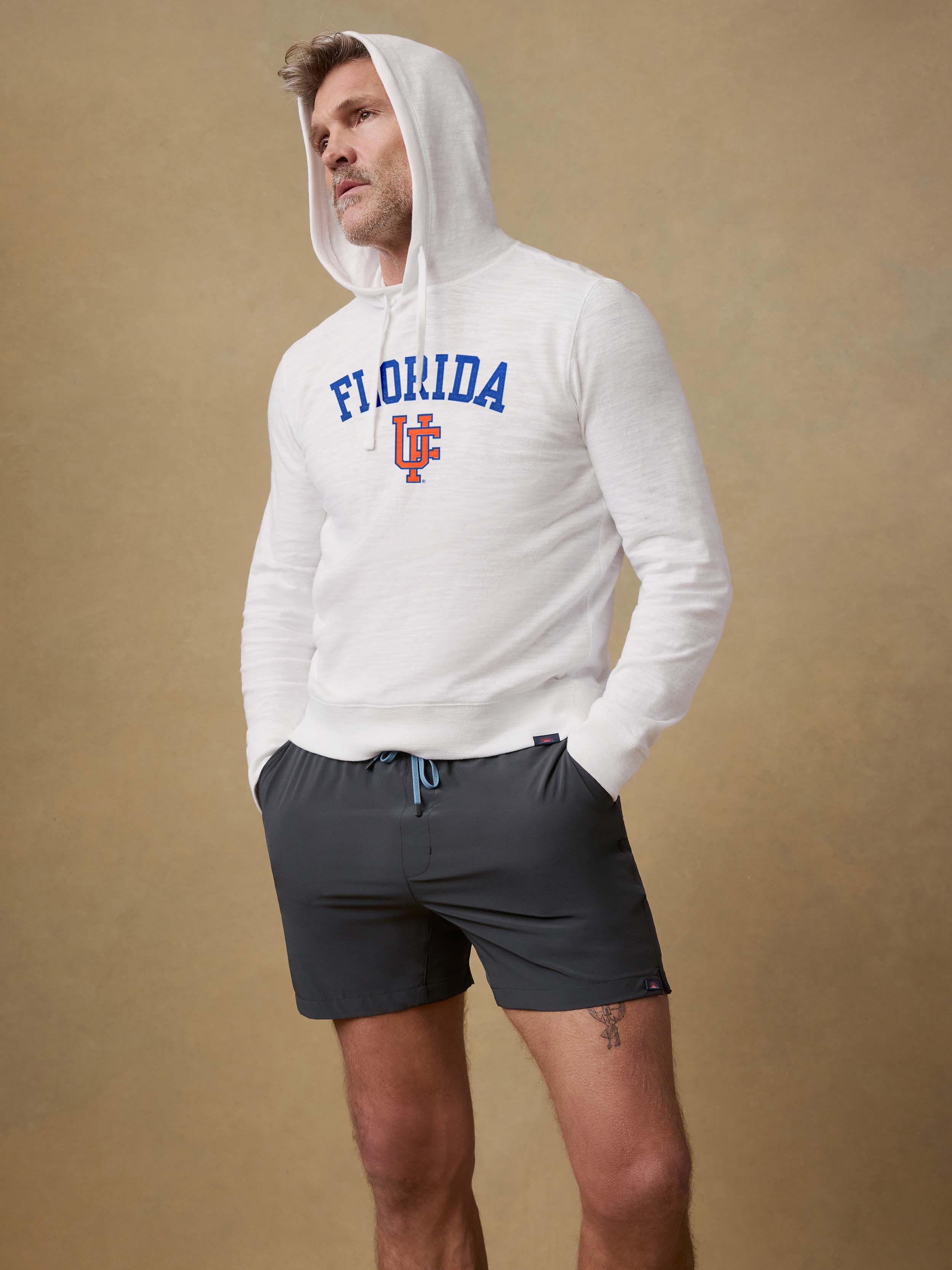 A man wearing a white University of Florida hoodie and black shorts
