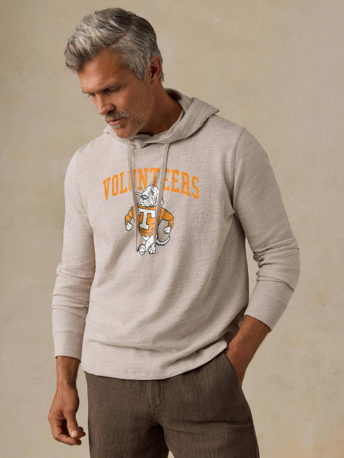 A man wearing a grey University of Tennessee  hoodie and brown shorts, image 1 of 1