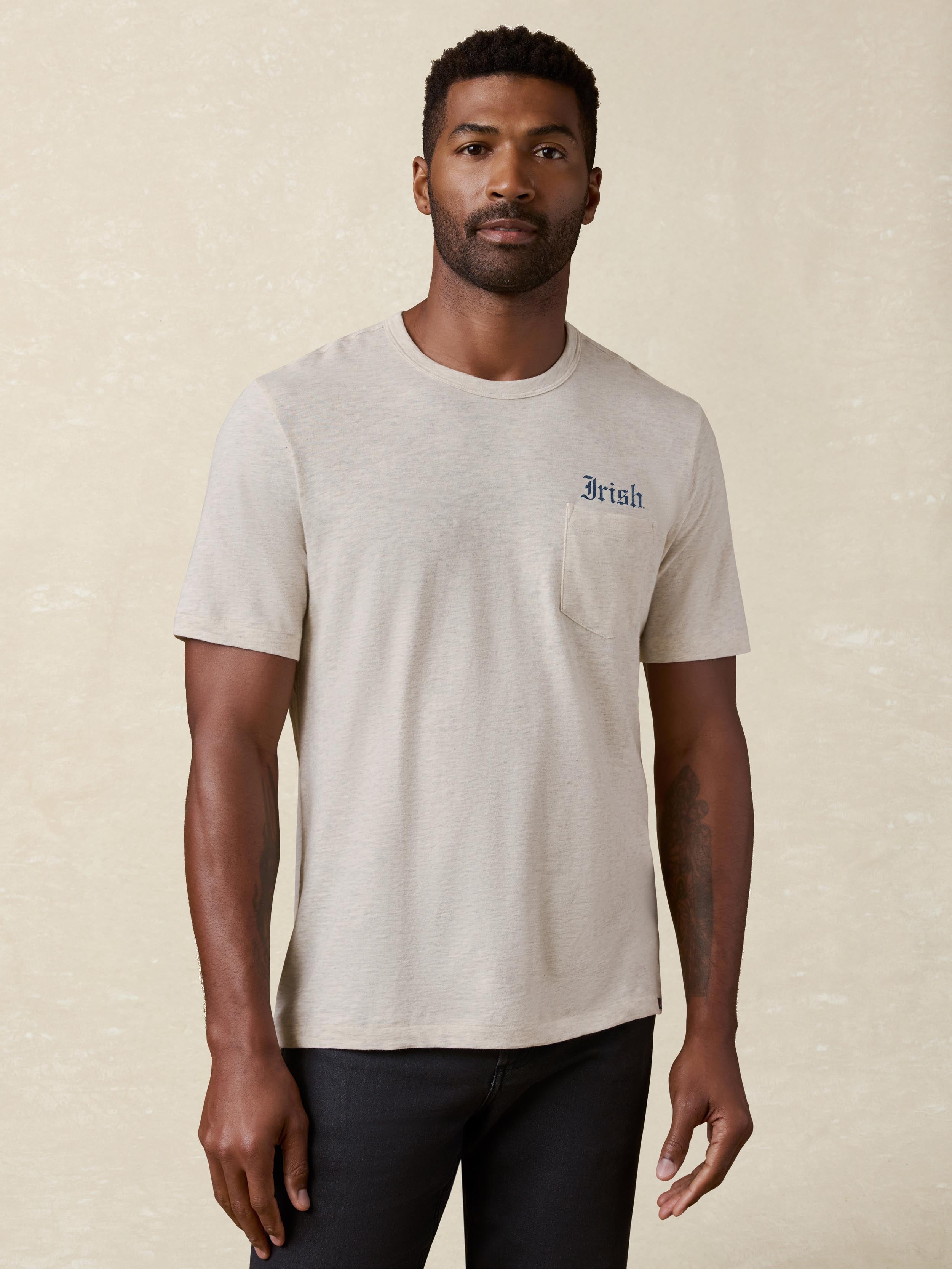 A man wearing a grey Notre Dame tee and black jeans