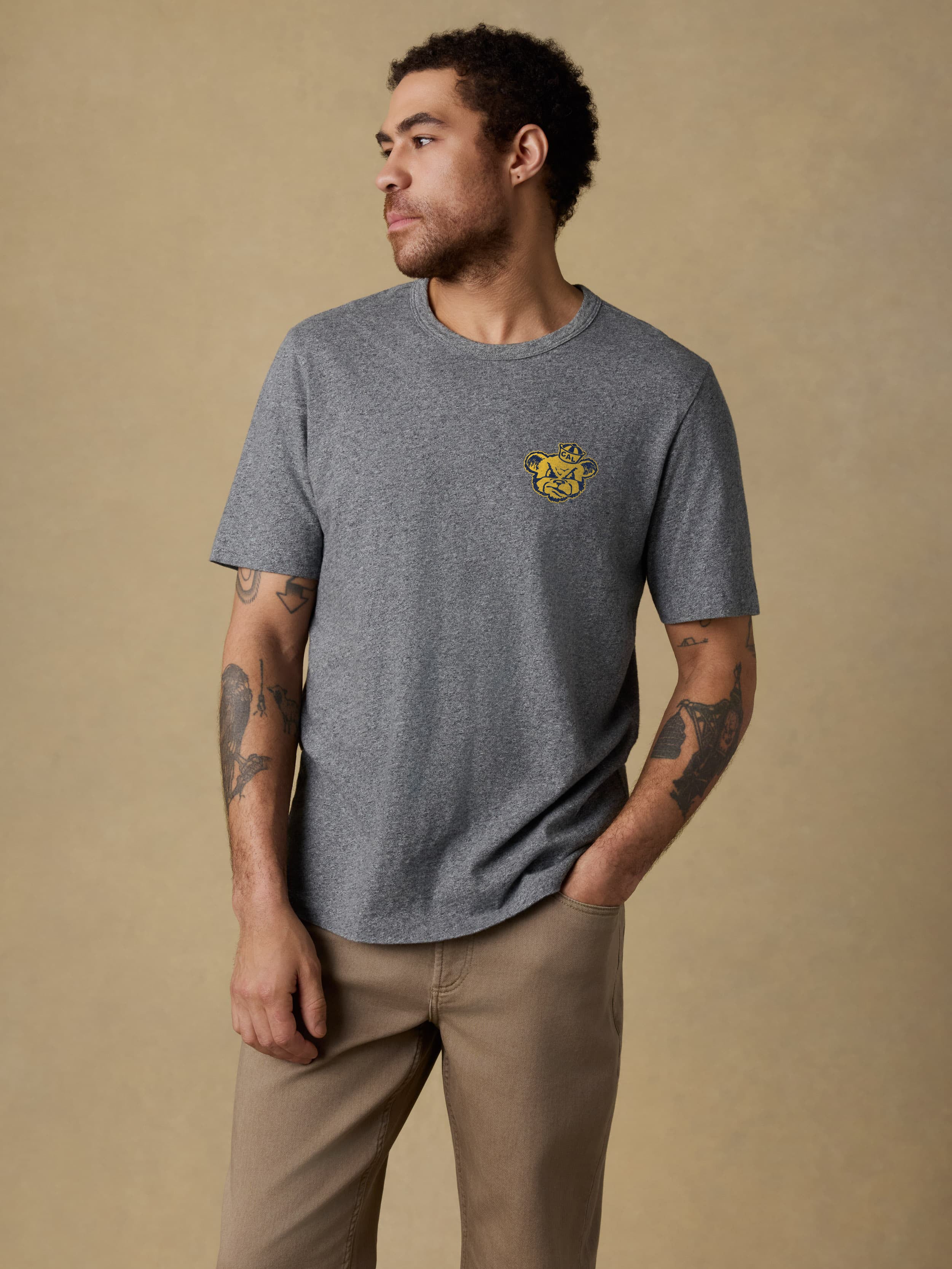 A man wearing a UC Berkeley tee and brown pants