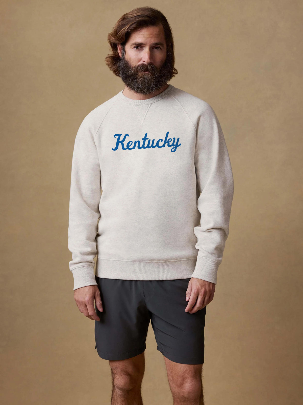 A man wearing a grey University of Kentucky crewneck and black shorts, image 1 of 1