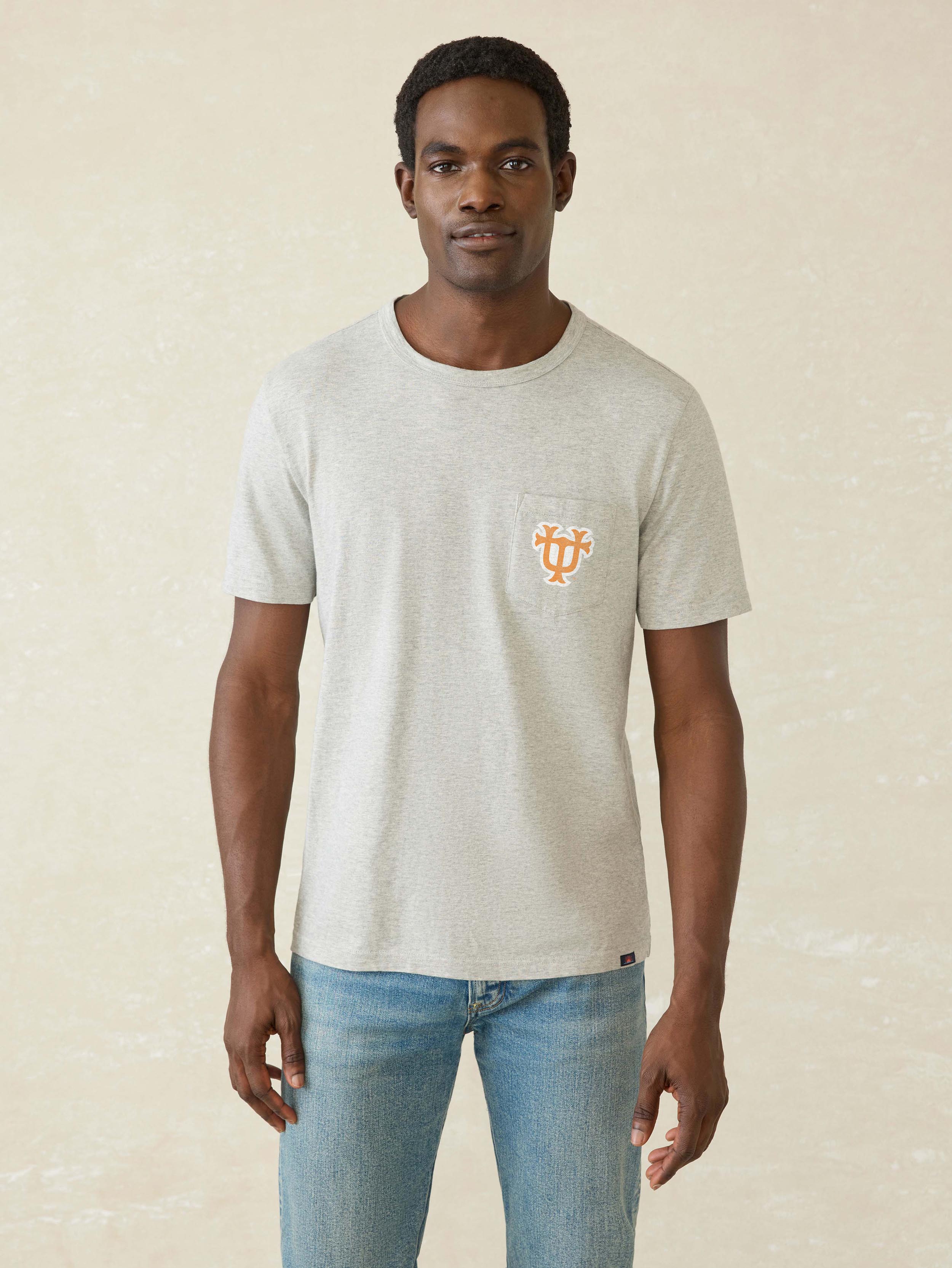 A man wearing a grey University of Tennessee tee and blue jeans