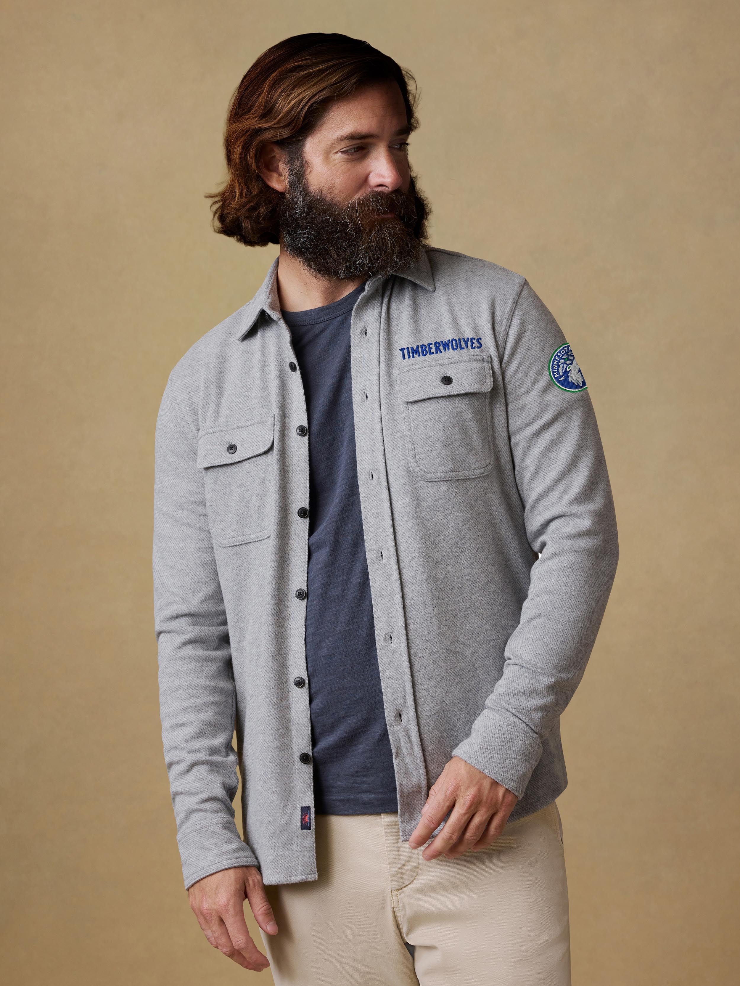 A man wearing a grey Minnesota Timberwolves button up shirt