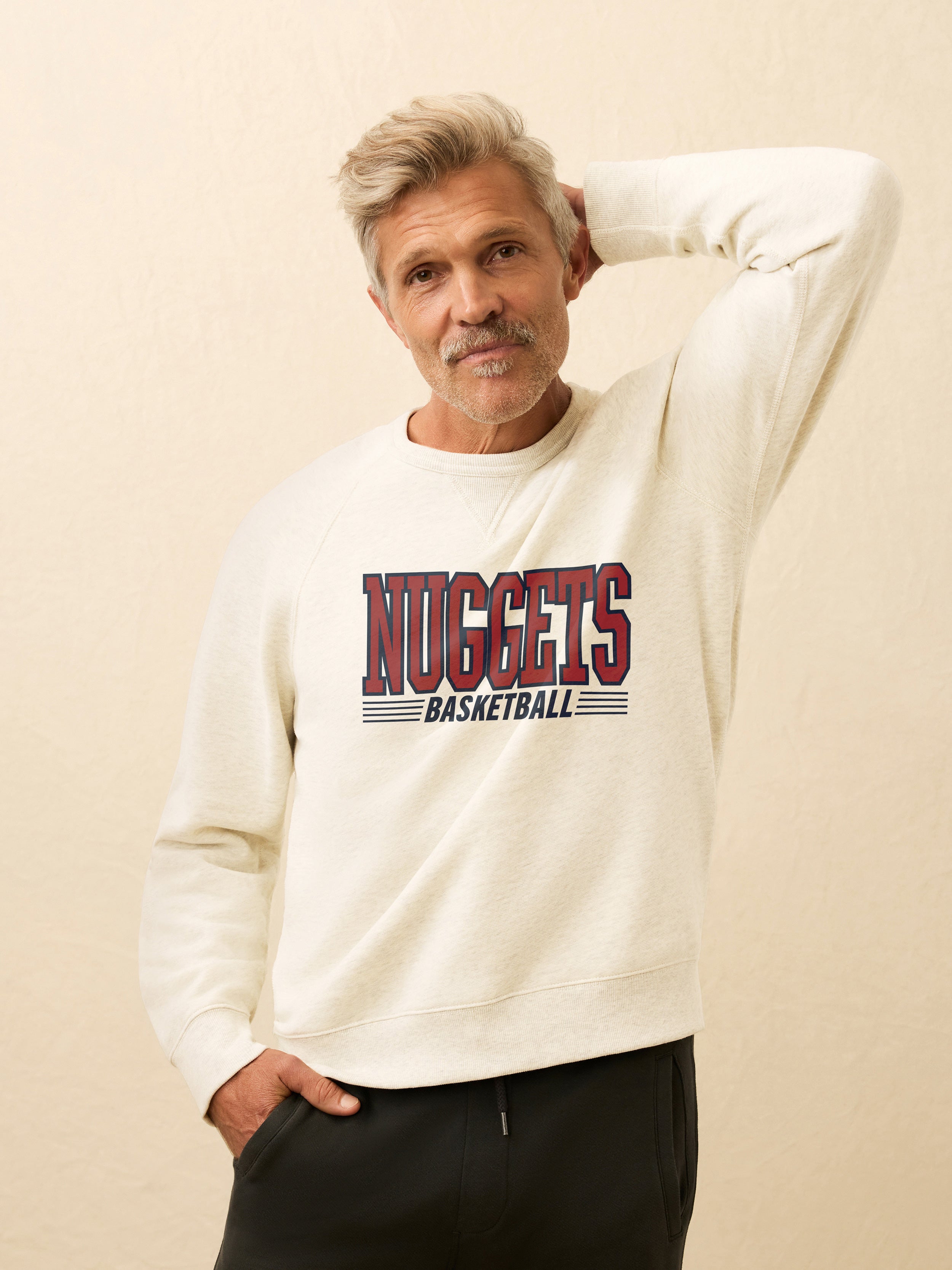 A man wearing a white Denver Nuggets crewneck